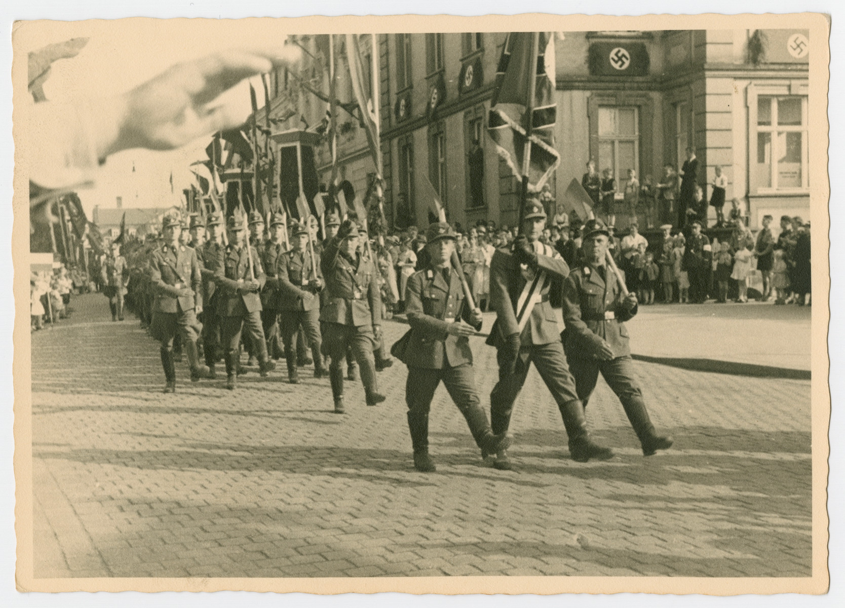 Nazis march down a street in Fulda during a May Day Nazi party parade.