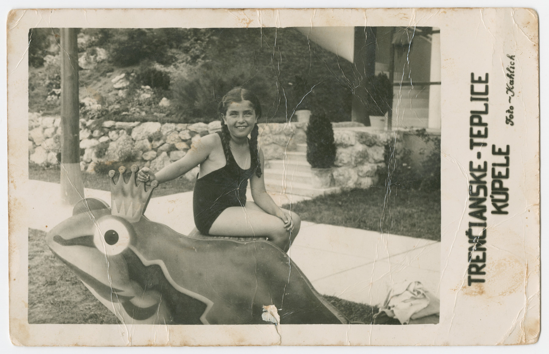 Hanka Wertheimer sits on a frog statue in her bathing suit at a swimming resort.