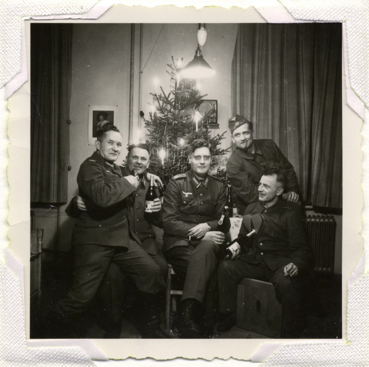 German soldiers pose in front of a Christmas tree.