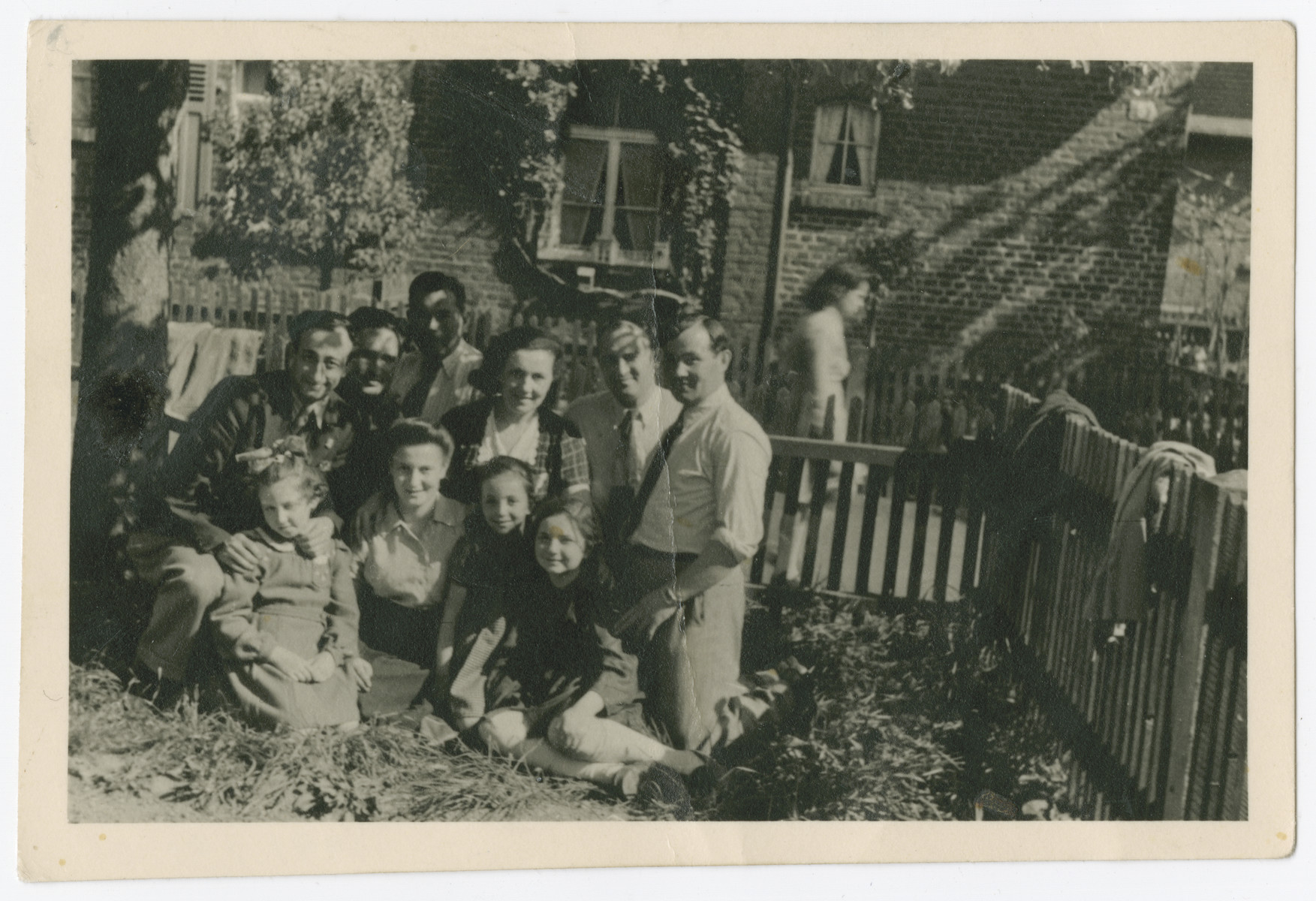 A group of men, women and children poses in a garden of the Zeilsheim displaced persons camp.

Miriam Pomerantz is sitting in the center.