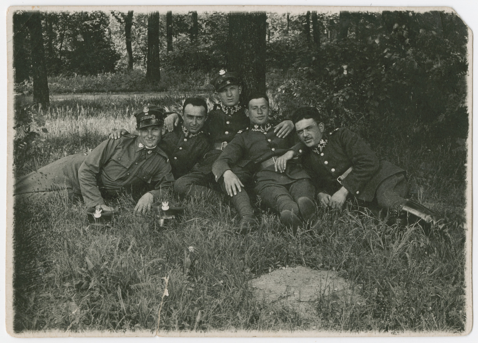 A group of Polish soliders relaxes under a tree.

Lt. Yehuda Bielski is pictured on the far left in his summer uniform.
