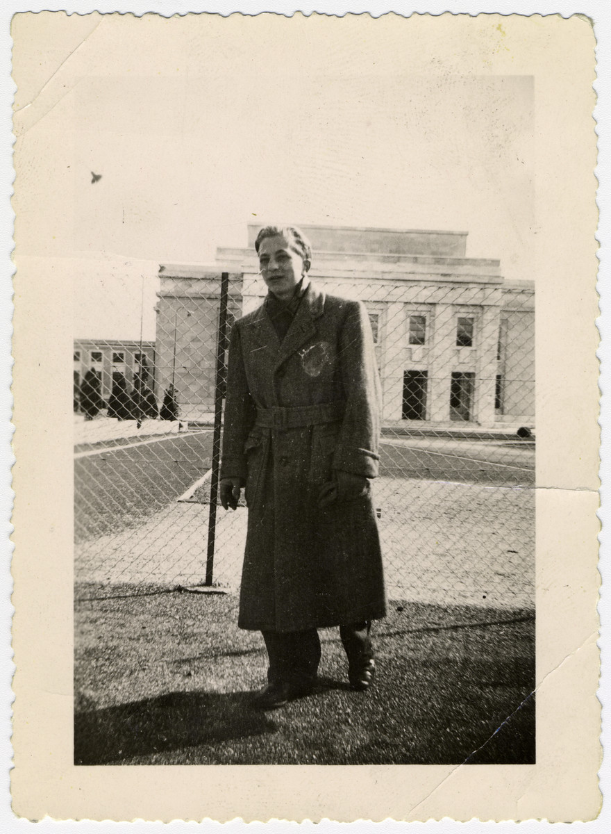 Close-up portrait of Henry Kolber, a teenage survivor  of Buchenwald. He is standing next to a chain linked fence in front of the Palais des Nations, the European headquarters of the United Nations.