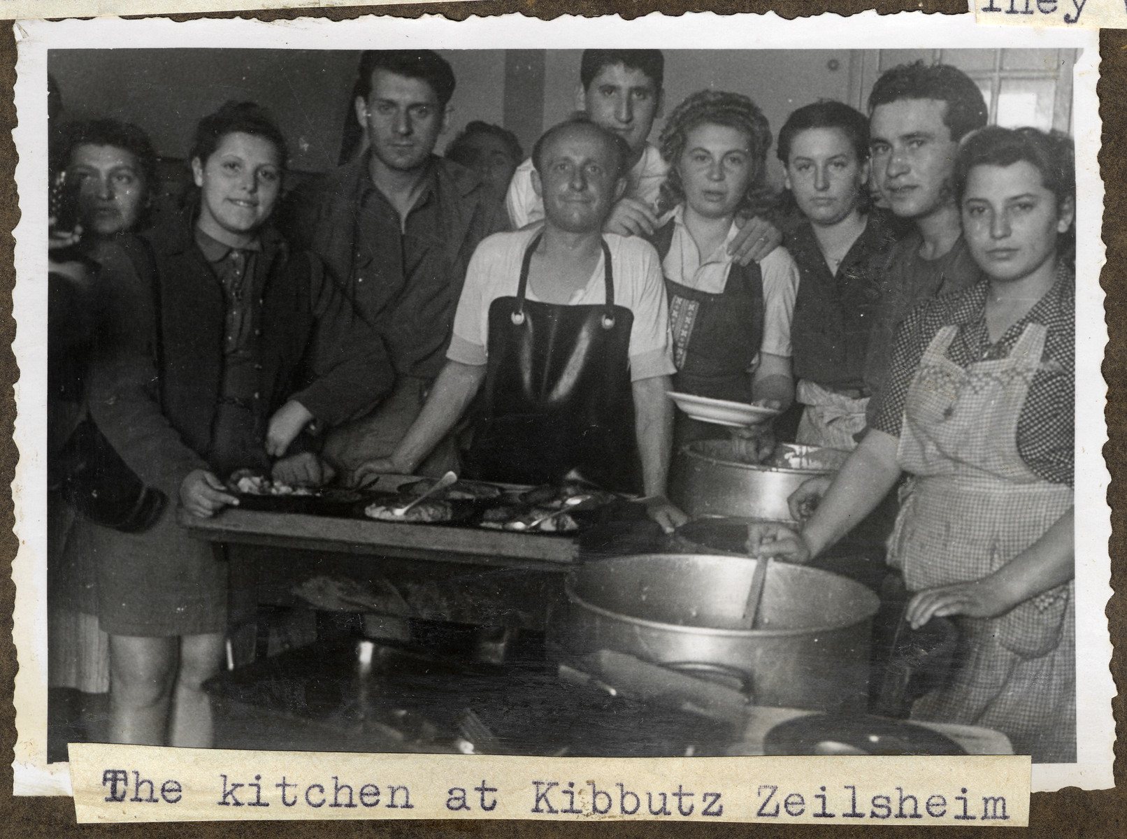 Jewish displaced persons gather around the stove in the kitchen in Kibbutz Zeilsheim