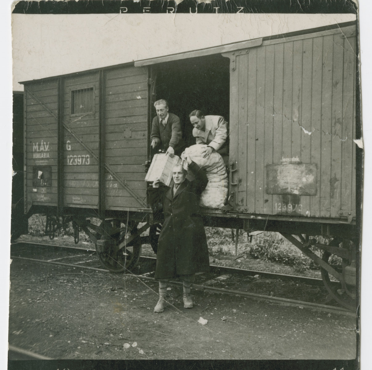 Hungarian Jews load or unload cargo into a cattle car while awaiting deportation to a forced labor battalion.

Among those pictured is Imre Winkler.