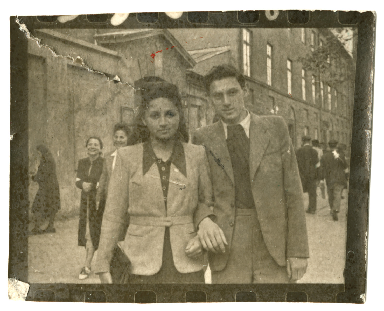 Miriam Wattenberg walks down a street in the Warsaw ghetto arm in arm with her with boyfriend Romek Kowalski.