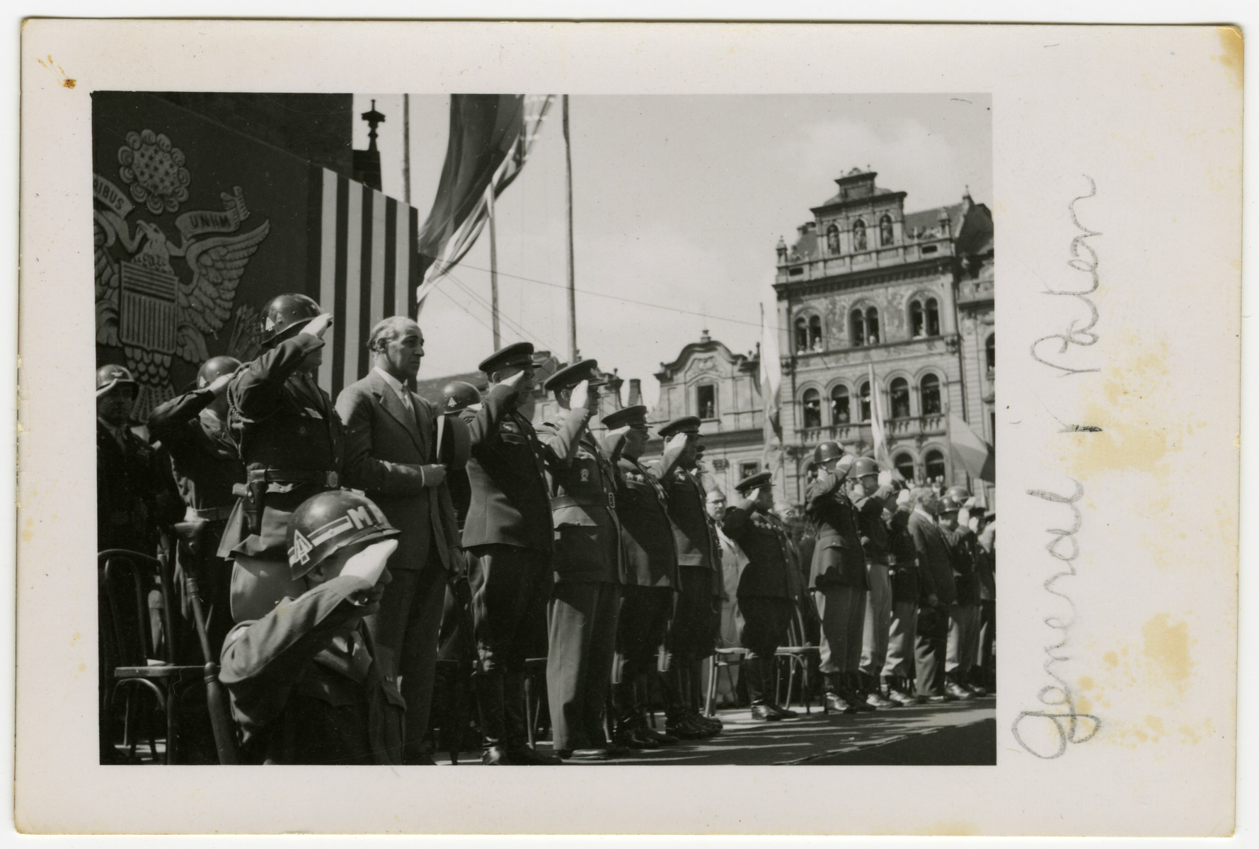 General George Patton stands on a reviewing stand and salutes along with several soldiers in Pilsen, Czechoslovakia on its liberation day.