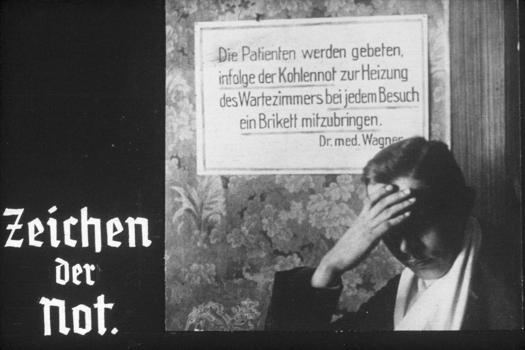 20th slide from a Hitler Youth slideshow about the aftermath of WWI, Versailles, how it was overcome and the rise of Nazism.

Zeichen der Not
(Signs of poverty)

Sign in photo reads: 
Die Patienten werden gebeten infolge der Kohlennot zur Heizung des Wartezimmers bei jedem Besuch ein Brikett mitzubringen

The patients are asked due to shortage of coal to heat the waiting room, to bring one briquette with each visit.