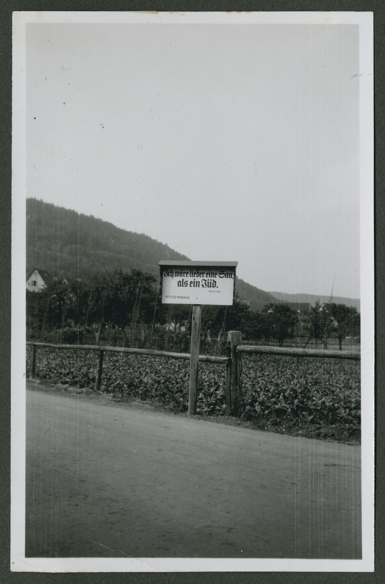 One photograph from an album of antisemitic signs in Germany.

The sign (in German) reads, "Ich waere lieber eine sau, als ein Jud. --Martin Luther.  NSDAP Eichenbach."  [I would rather be a sow than a Jew.]