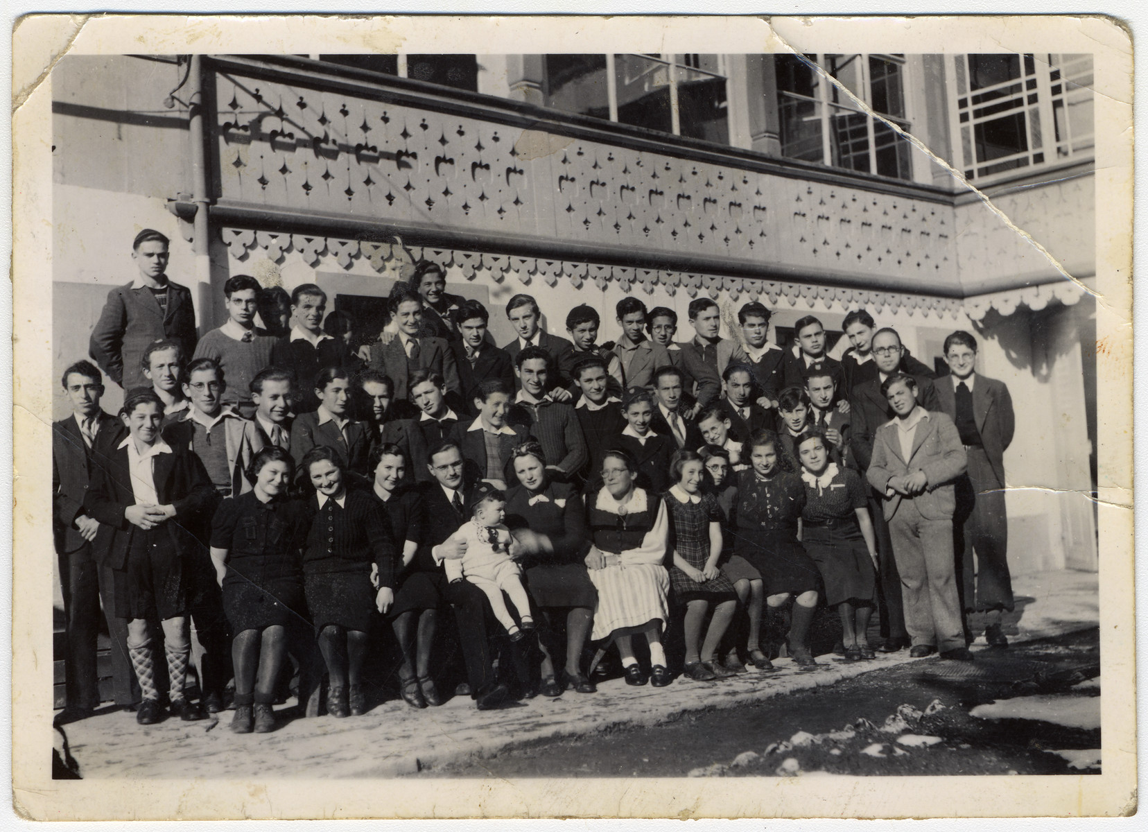 Group portrait of residents of an Orthodox children's home in Basel.

Rabbi Stern is pictured in the front row, center with his wife.  Next to his wife is Miss Riesner, the sewing teacher.  Ruth is sitting next to Miss Riesner.