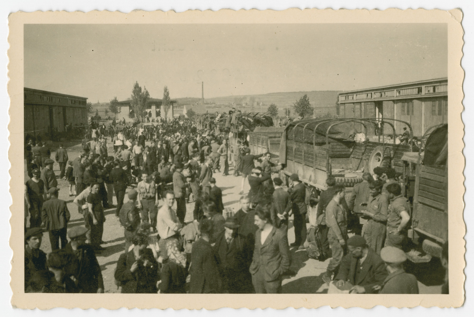 A group of survivors get off transport trucks on arrival [probably at the [Eisenach displaced persons camp.]

The original caption reads, "They unload and get deloused and there is much confusion and they are human beings with hopes."