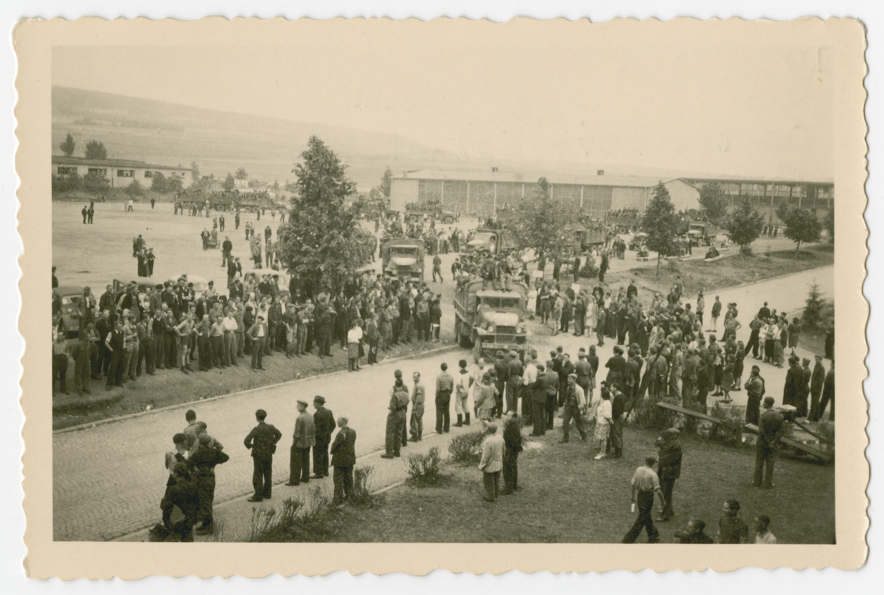 Survivors depart Buchenwald concentration camp by truck after the camp was liberated.

The photograph's orginal caption reads, "On the move and at the entrance the ones remaining say and wave good by. Or mainly look on - knowing they'll be next."