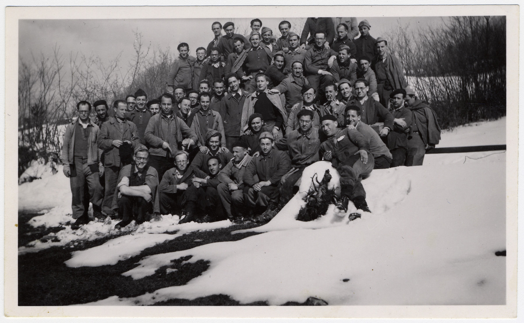 Group portrait of Jewish internees posing in the snow in an unidentified Swiss labor camp.

Max Schattner is pictured in the first standing row, second from the left.