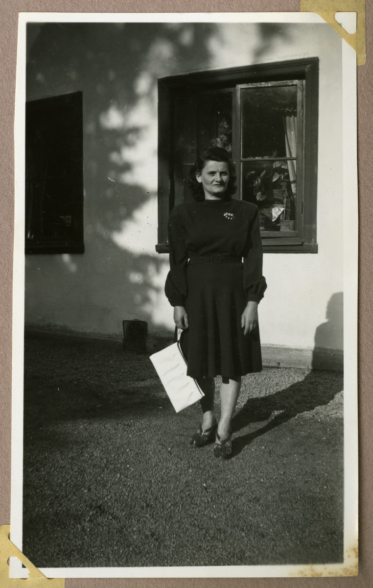 Photograph of a Jewish Holocaust survivor Rose Kahane Leibovic poses otuside a building in Sweden.