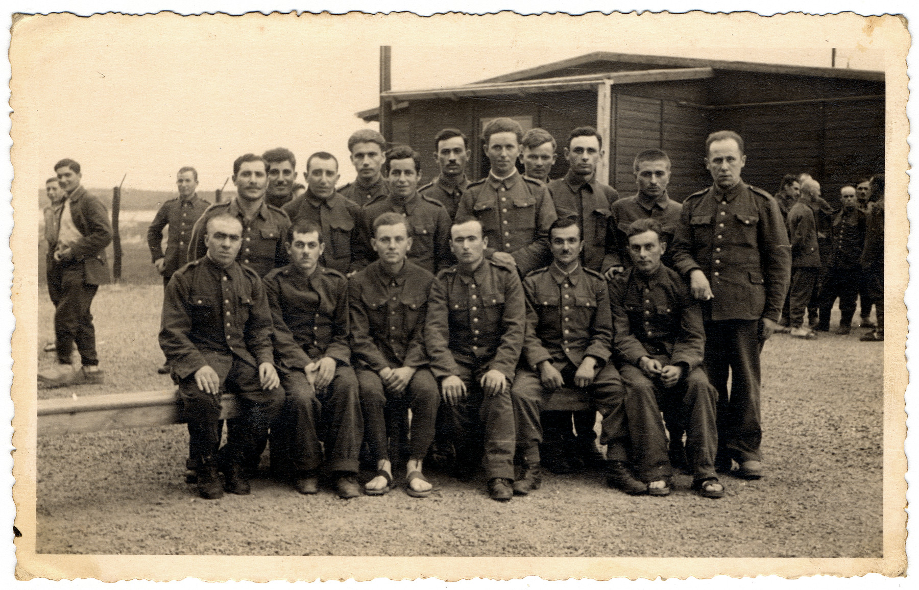 Group portrait of prisoners in the Elsterhorst prisoner of war camp, Stalag IV-A.

Jan Szelubski is pictured standing, fifth from the left.
Rio Francis is pictured sitting, first on right.