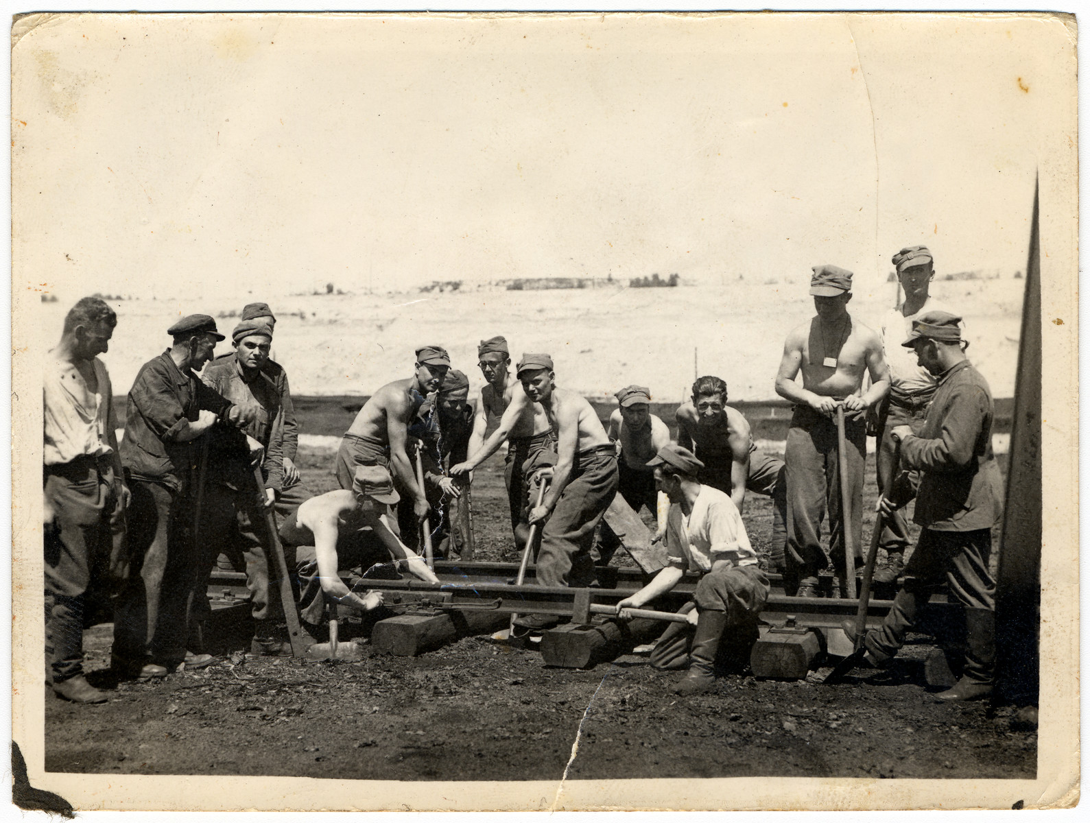 Prisoners in the Elsterhorst POW camp perform forced labor building or repairing train tracks.