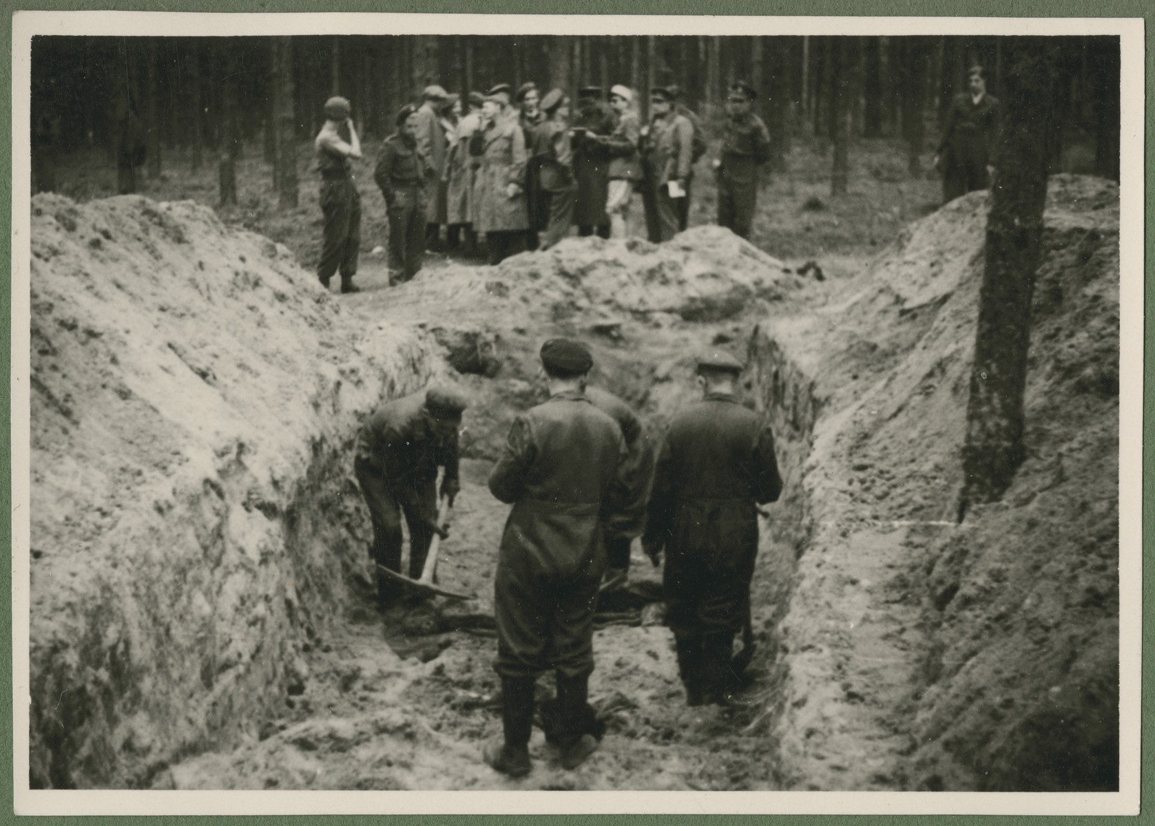 Under the supervision of British troops, German civilians and Nazi officials exhume the corpses of 243 slave laborers for proper reburial.  The victims were shot by their guards on the railway lines at Lueneberg on the way to the Belsen Camp.
