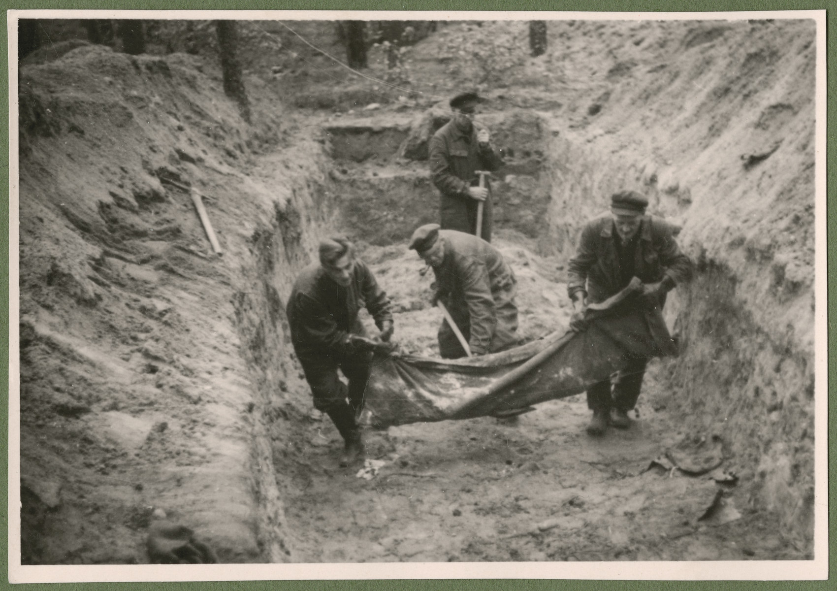 Under the supervision of British troops, German civilians and Nazi officials exhume the corpses of 243 slave laborers for proper reburial.  The victims were shot by their guards on the railway lines at Lueneburg on the way to the Belsen Camp.