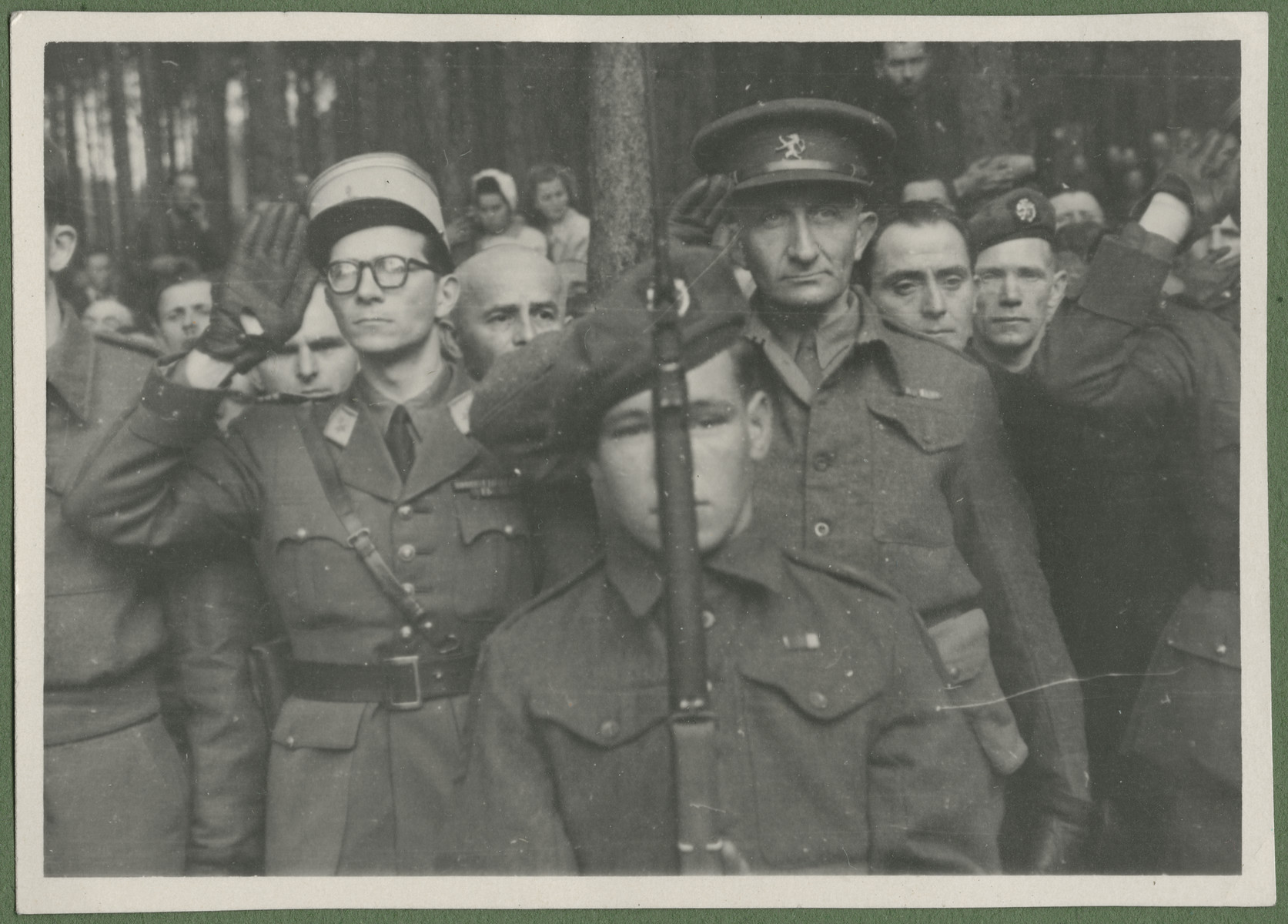 Belgian and British soldiers pay their lfinal respects to the 243 slave laborers who were shot by their guards on the railway lines at Lueneburg on the way to the Belsen Camp. 

Maurice Frank is pictured in the center, right.