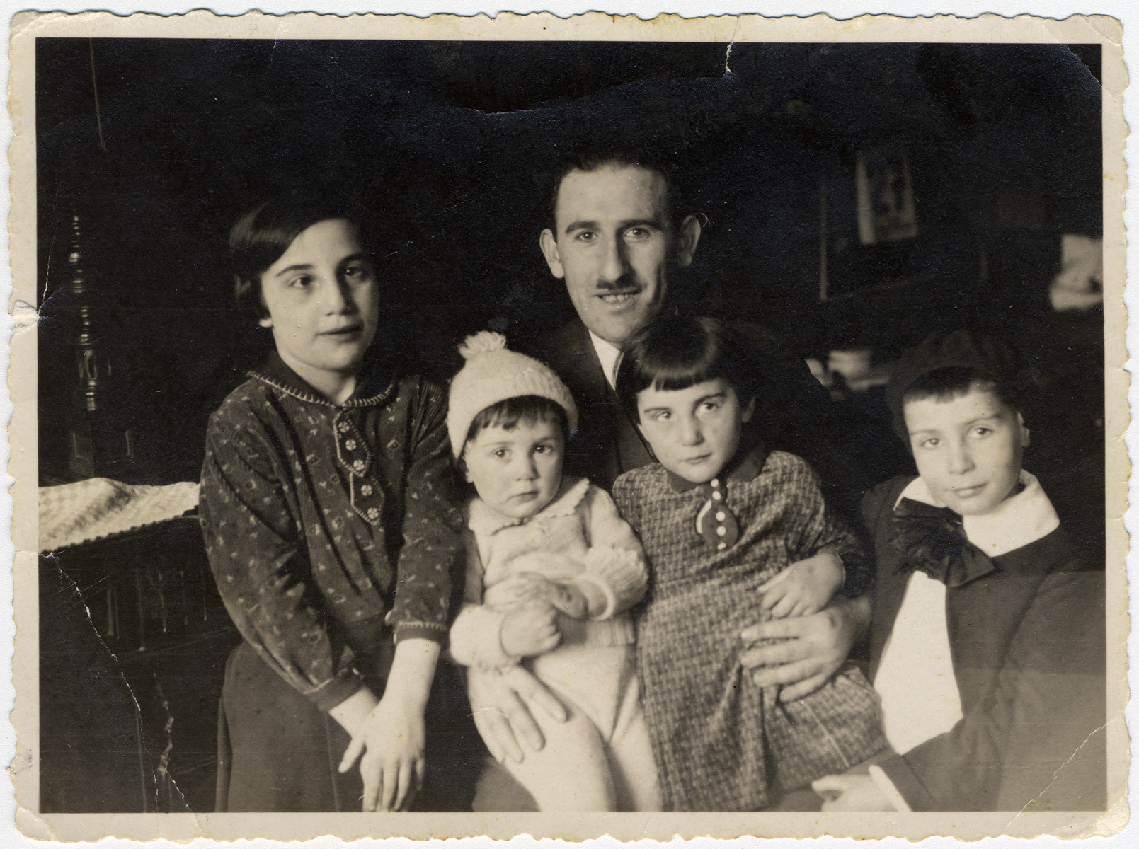 Simon Bloch poses with his four children gathered around him.

From left to right: Lore (later Schwab), Julius Israel, the father Simon Bloch, Margot (later Klein) and Max.  The following year they moved to Strasbourg following the Nazi take-over of Germany.