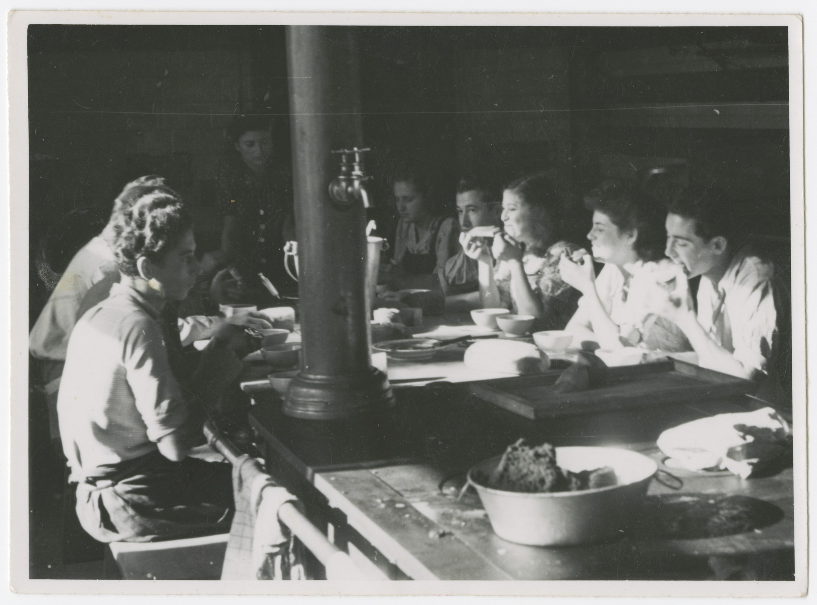 Zionist youth, some who came to Switzerland on the Kasztner transport, share a meal in the dining room of a kibbutz hachshara near Bern.

Eva Weinberger is pictured sixth from the right.