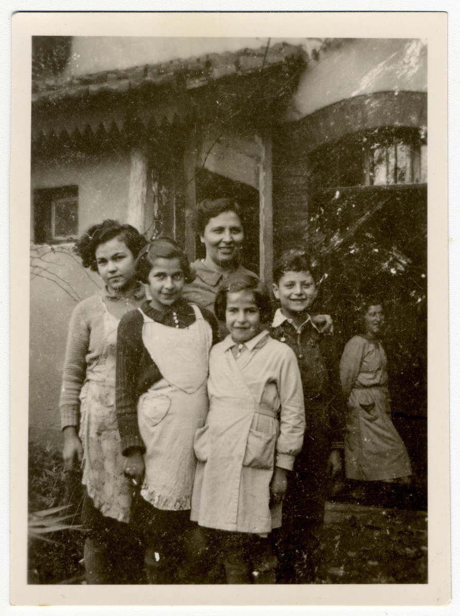 Group portrait of girls and staff at Home General Bernheim in Zuen, Belgium.

 In front, from left, the Rosenblatt sisters - Else, Regina and Toni. In rear Mrs. Flora Schlesinger, the colony's cook from Vienna and her son Paul Schlesinger. At right, in background, Schlesinger's helper, Irma Seelenfreund.