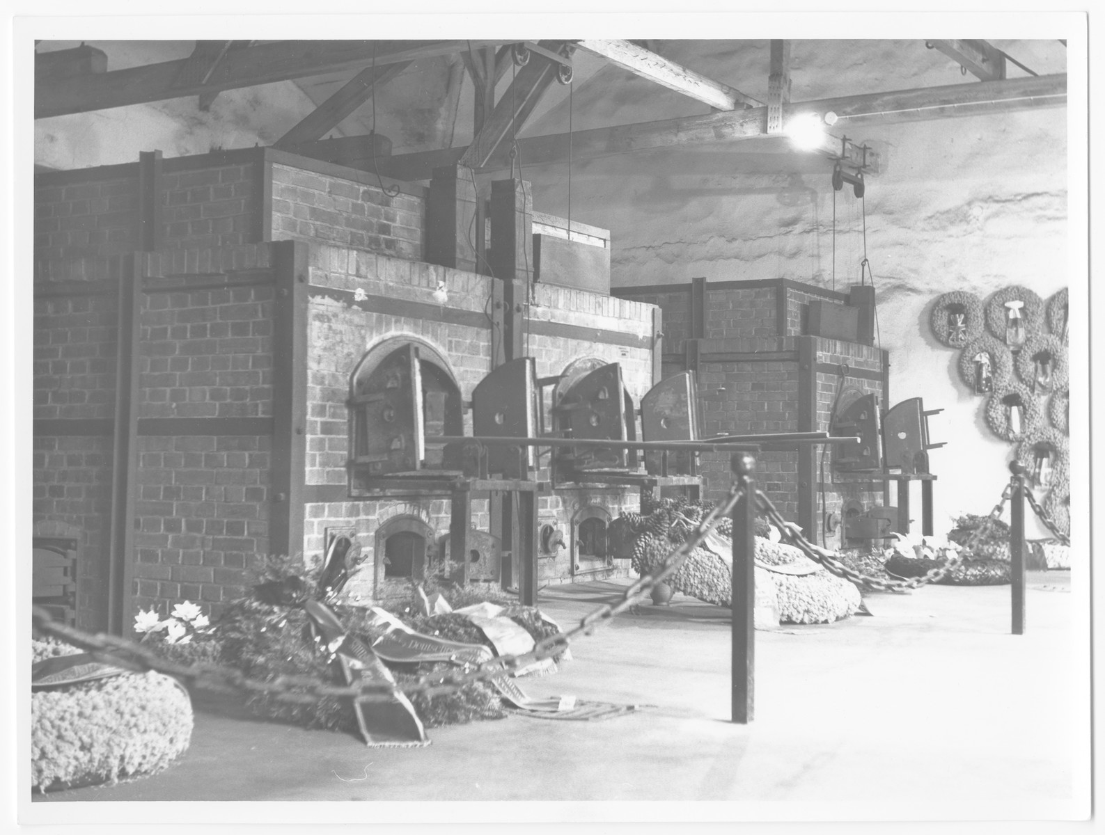 Postwar view of wreaths bedecking the interior of the Dachau crematorium.