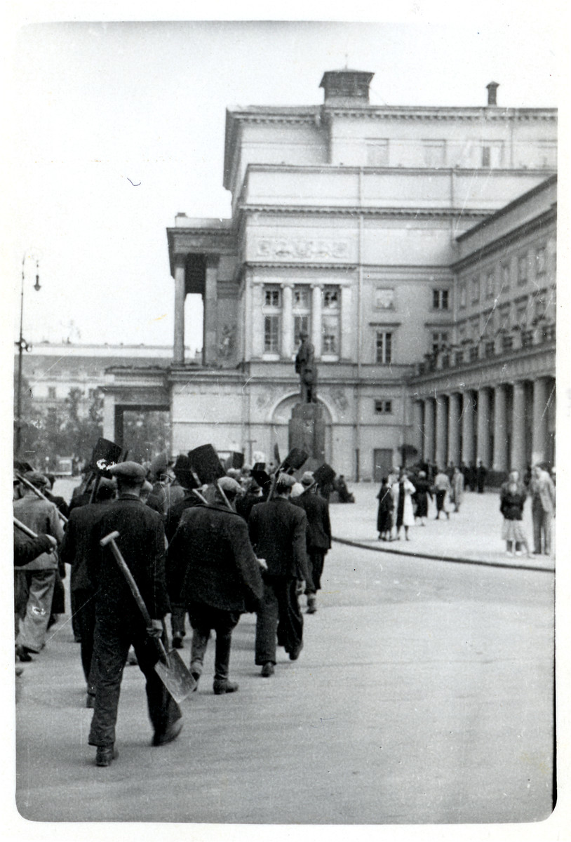 Polish men march past the Great Theatre in Warsaw to dig anti-tank trenches against the German Army.