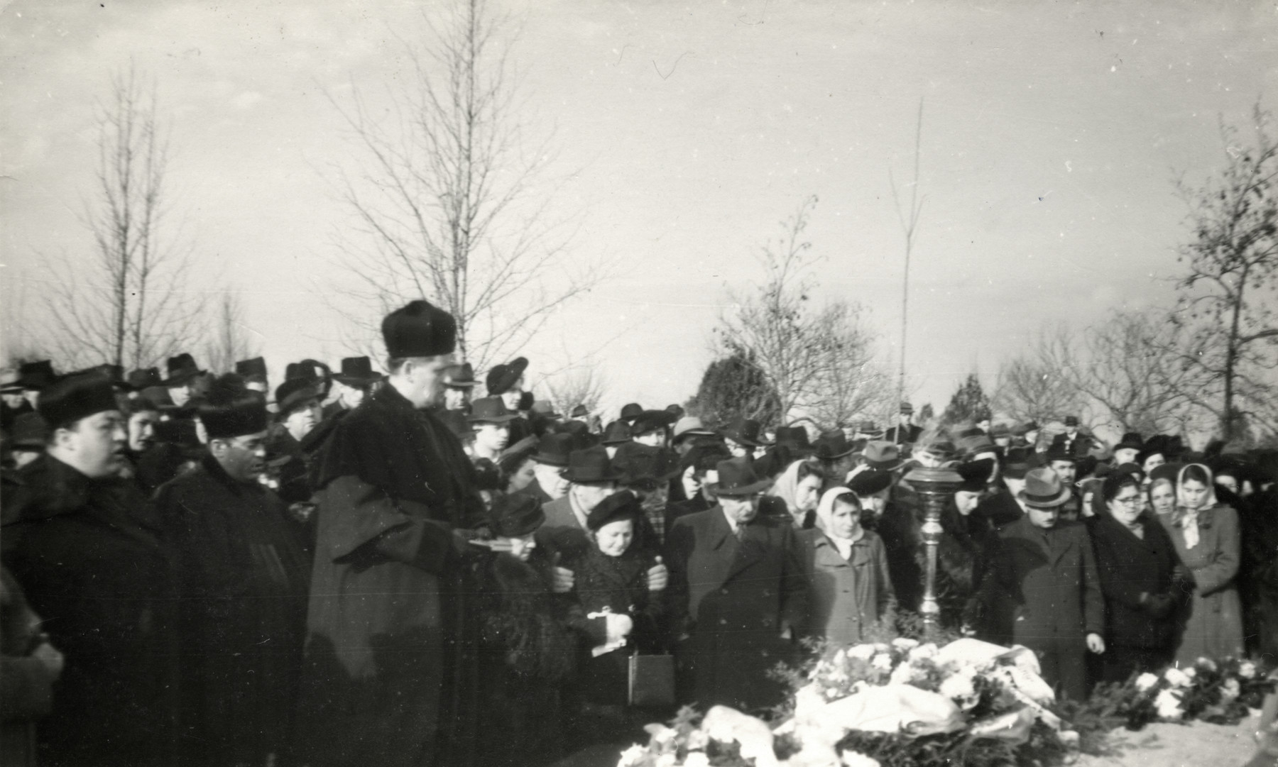 Rabbi Jeno Frenkel leads a memorial service following the exhumation and reburial of Jewish Holocaust victims.

Their bodies were exhumed in Strasshof\ and reburied in Szeged, Hungary.

Among those attending is Pal Gyulai, a survivor  who worked with Rabbi Frankel on this project to return victims remains from Strasshoff, Austria.