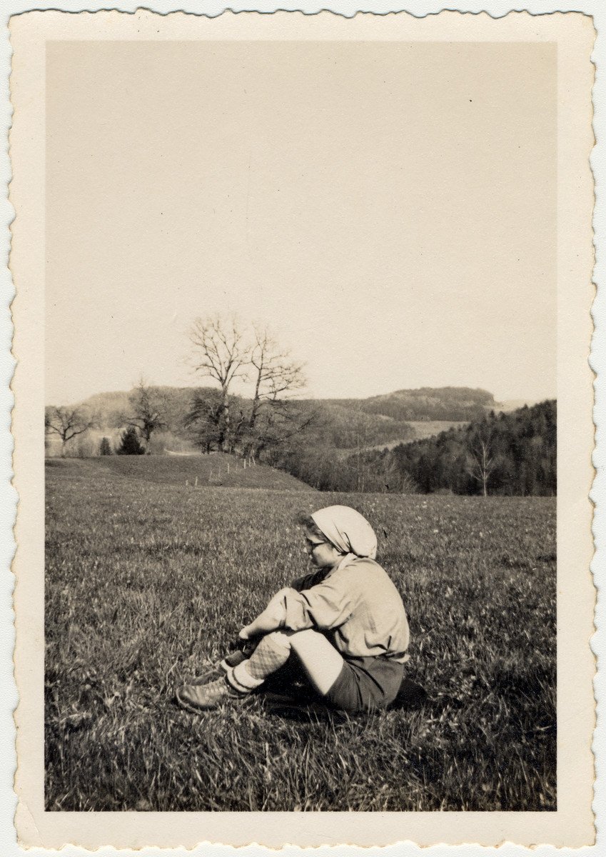 Minni Pickholz, a member of the Zionist youth movement, sits lin an open field probably in Elgg.