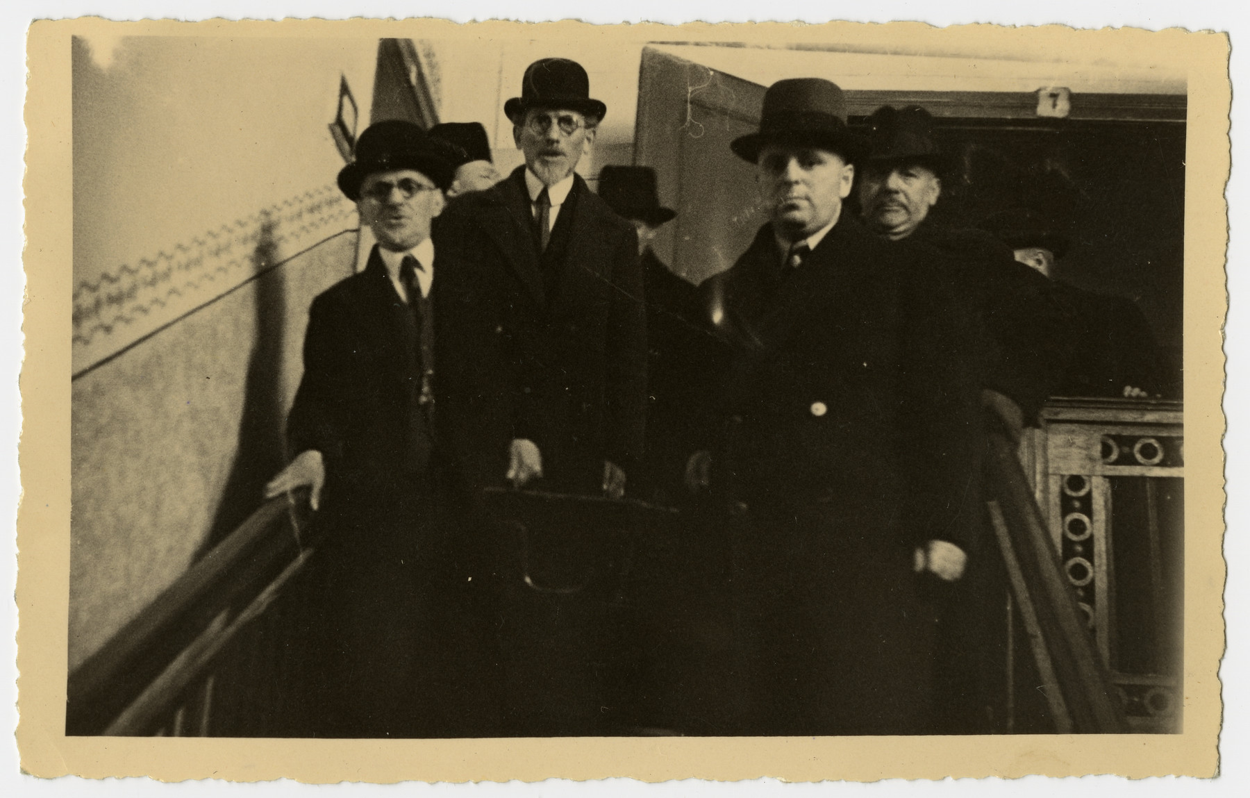 The body of Freida Albin is carried down the stairs prior to her funeral.

The husband of Rosa Preiss is in front, and Mr. Rosenthal is in the back.