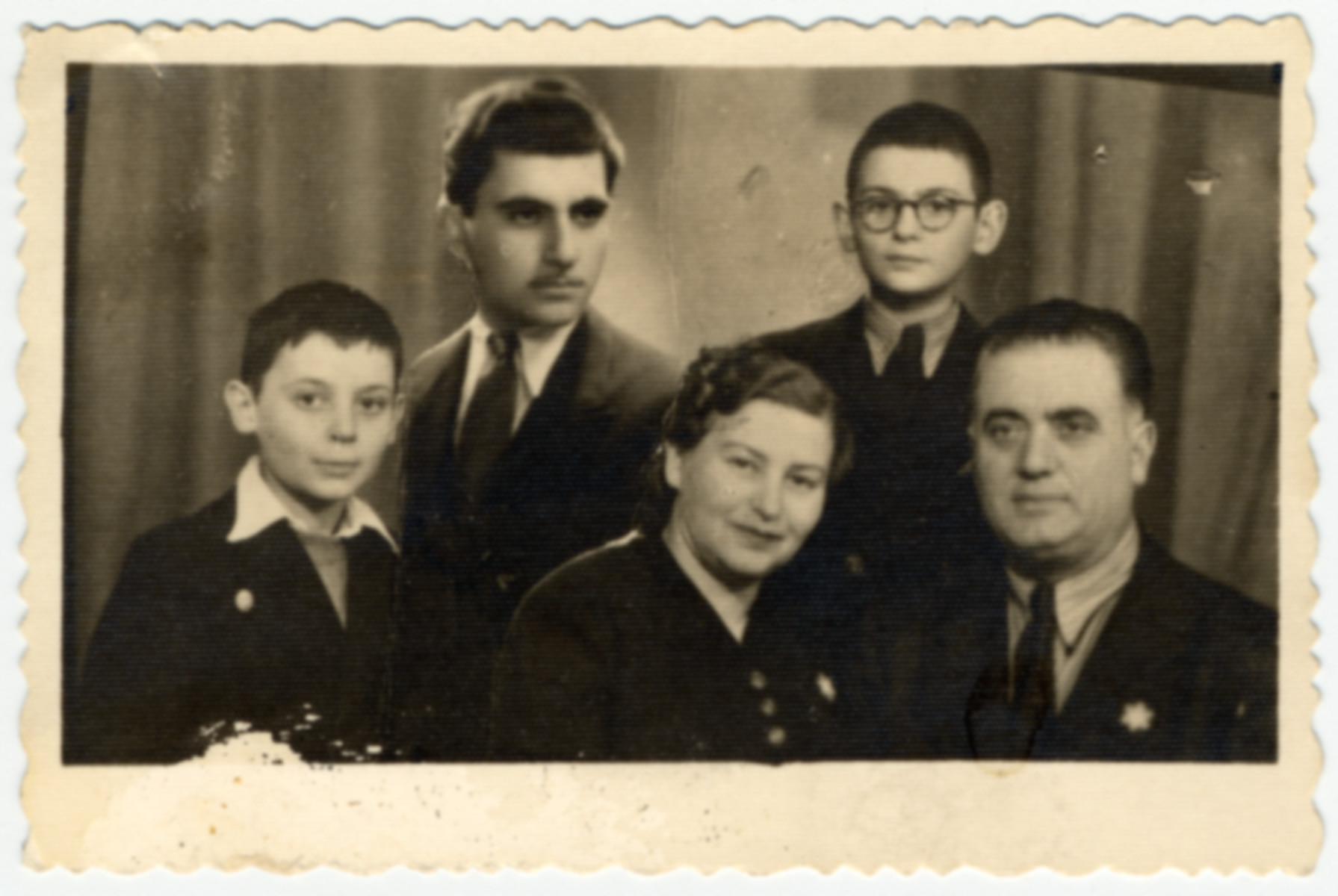 Composite photograph of the Farhis, a Bulgarian Jewish family wearing Stars of David.

The oldest son David was not present for the photograph so his picture was added later.  Also pictured from left to right are Moise, Karolina, Albert and Nissim Farhi.