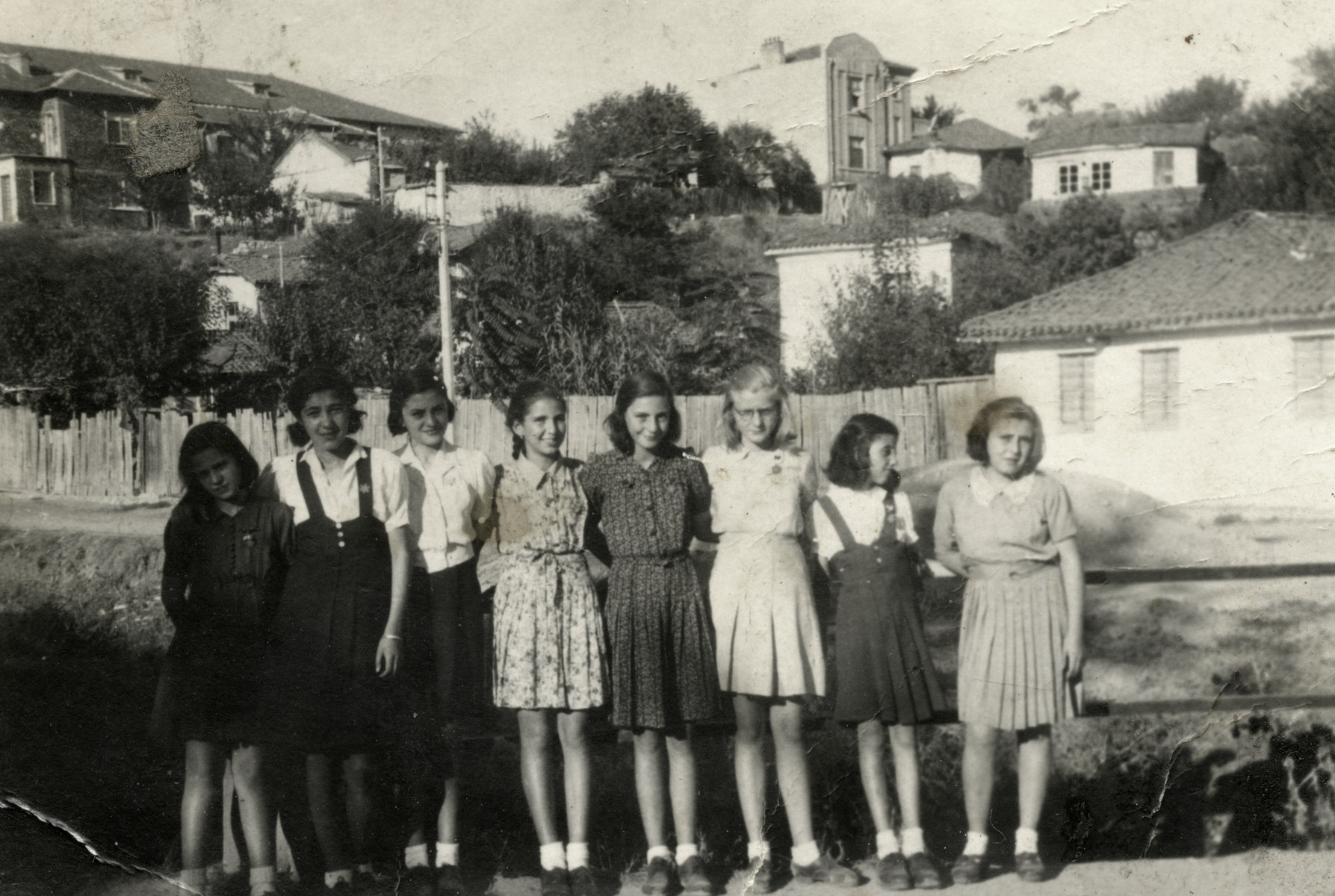 Group portrait of Jewish school girls outdoors in Haskovo; all are wearing Jewish stars.

Reine Behar is pictured third from the right.