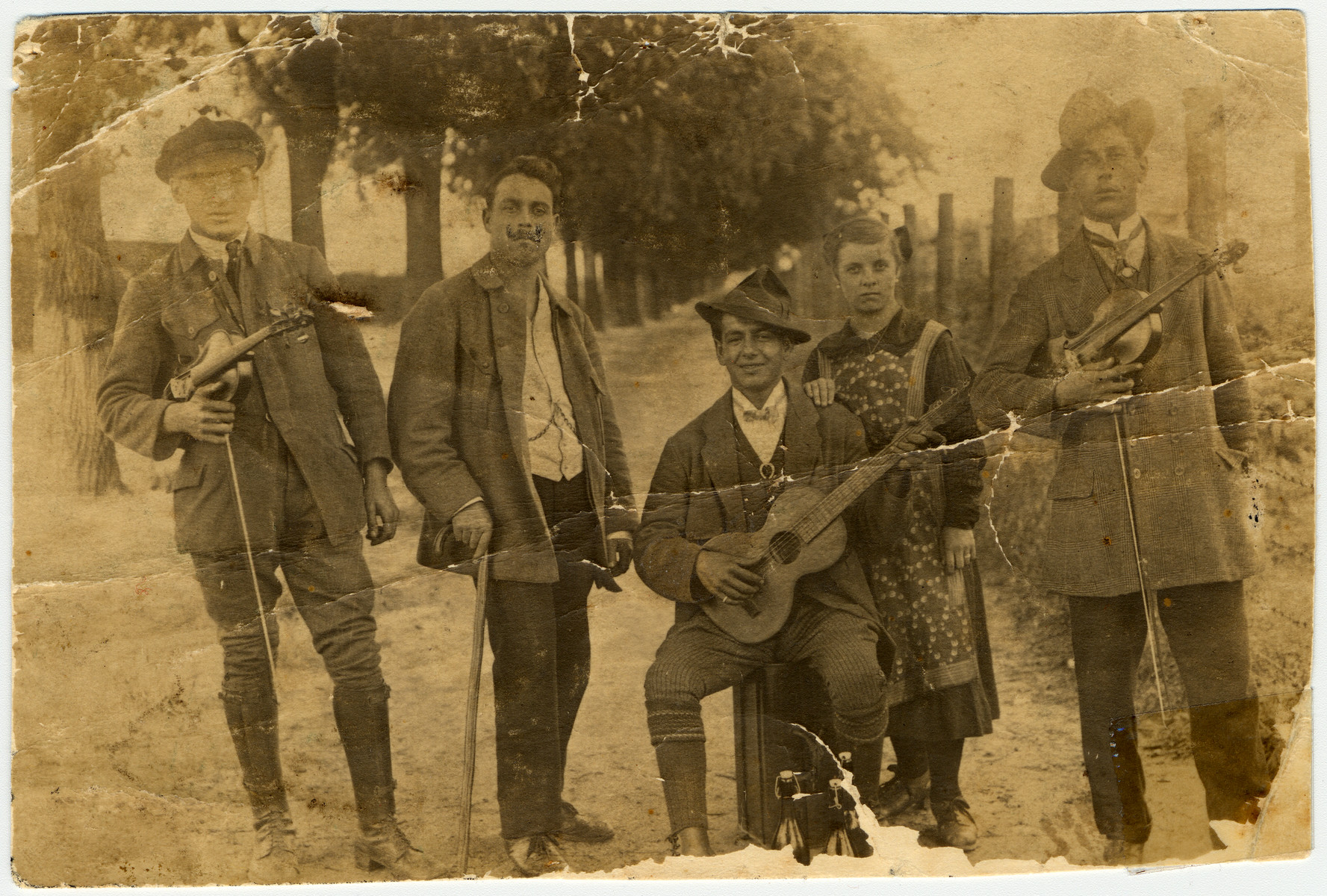 Members of a French-Hungarian Romani musical band pose for a photograph with their instruments.  

Pictured are members of the donor's family: in the middle, with the cane, is donor's grandfather, Johann Winterstein.  Surrounding him are his cousins.  The band was mostly performing in France.