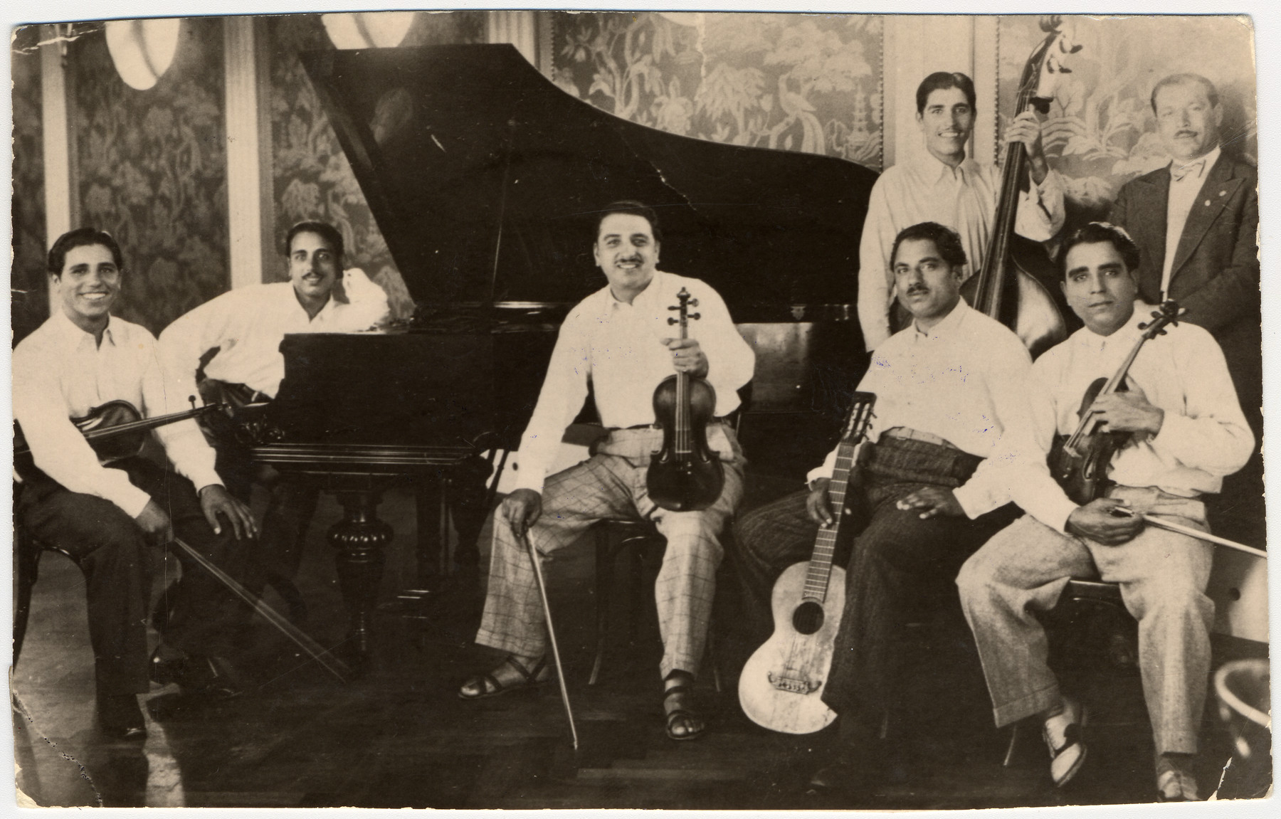 Members of a French-Hungarian Romani musical band pose for a photograph with their instruments.  

Pictured from left to right are: Gabriel Reinhardt (donor's father), Benjamin (donor's uncle), Johan (donor's uncle), a cousin, Ben (donor's uncle), Josef (donor's uncle) and unknown [maybe another cousin].  The band was banned and all its members were sterelized in Wuerburg.