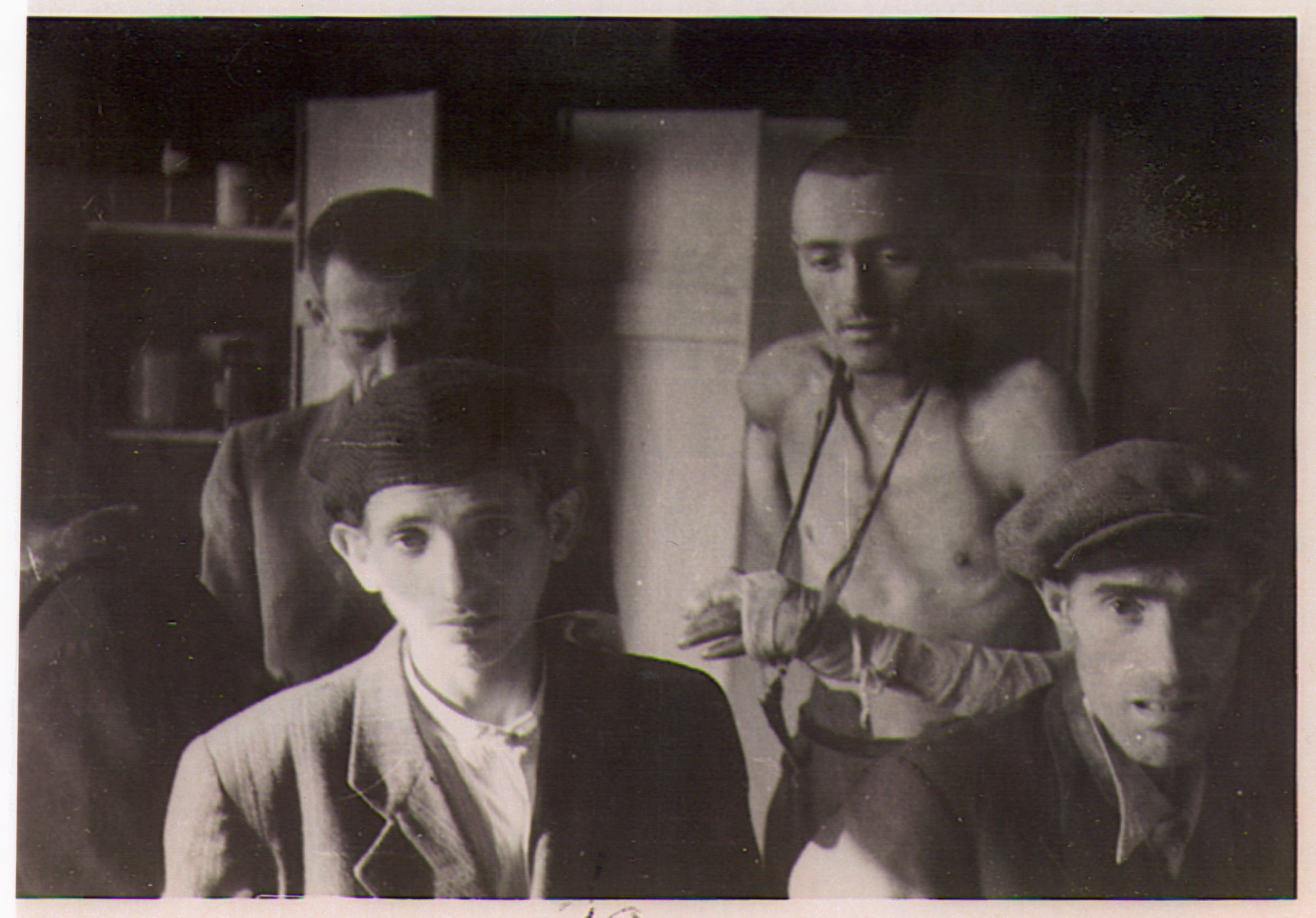 Four survivors of the Hanover-Ahlem concentration camp pose inside of a barrack.