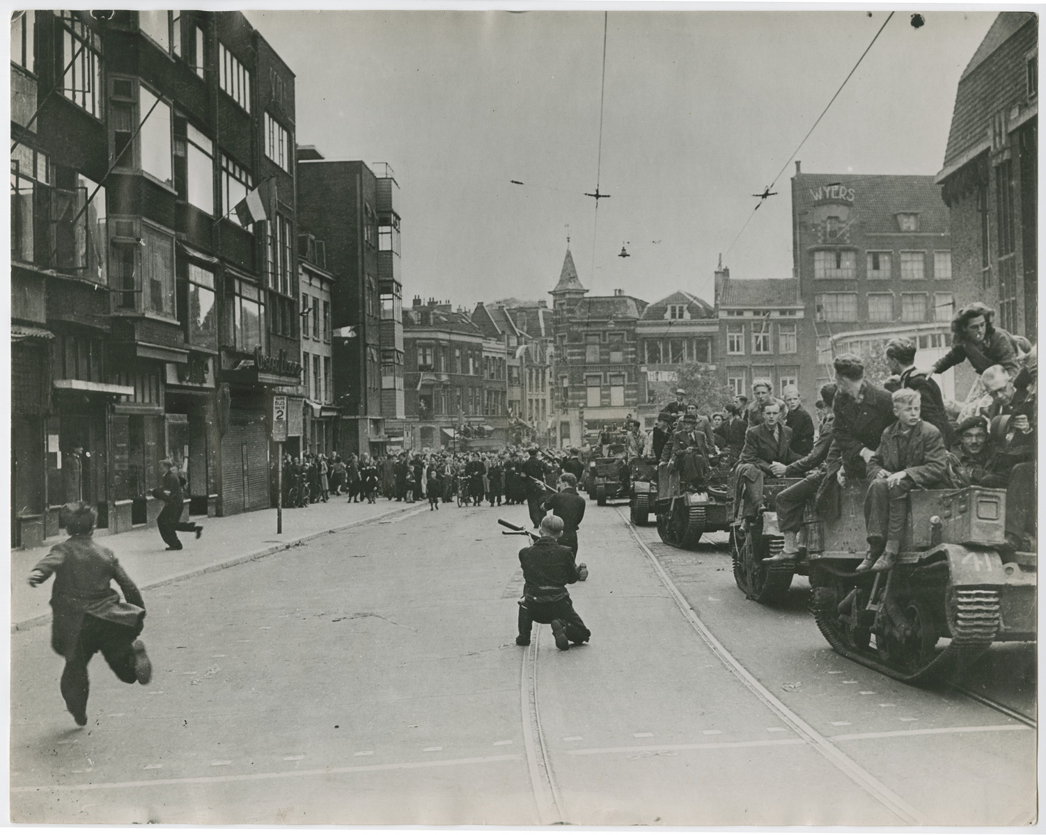 Sharpshooters aim at German snipers who fired at a Dutch victory parade in Utrecht.  

Original caption reads:  "Crowds celebrating victory in the streets of Utrecht, Holland, are fired on by Nazi fanatics hiding in a building overlooking the parade.  After a sharp skirmish, the Germans were captured by Dutch patriots and the celebration was resumed.  Here, as the Nazis open fire on the victory crowds, Dutch patriots go into action".