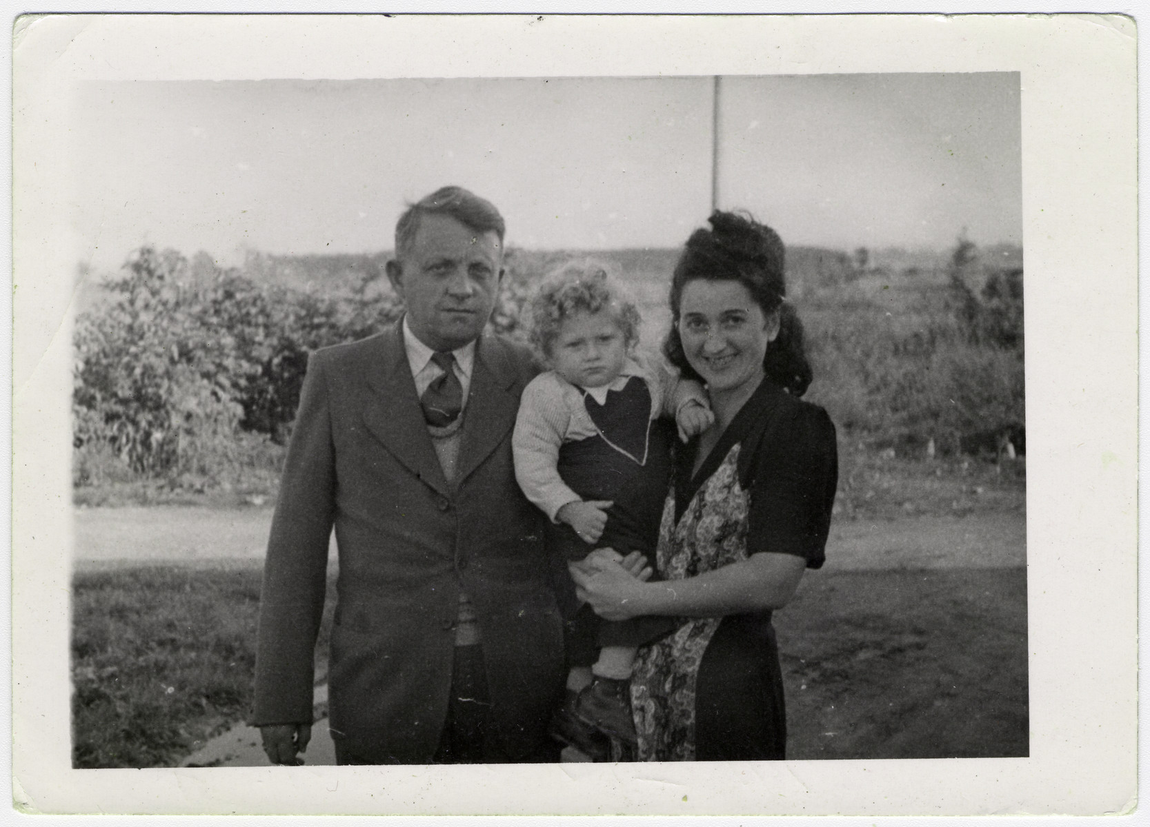 The Beer family poses outside in the Pocking displaced persons' camp.

From left to right are Leo, Max and Genia Beer.