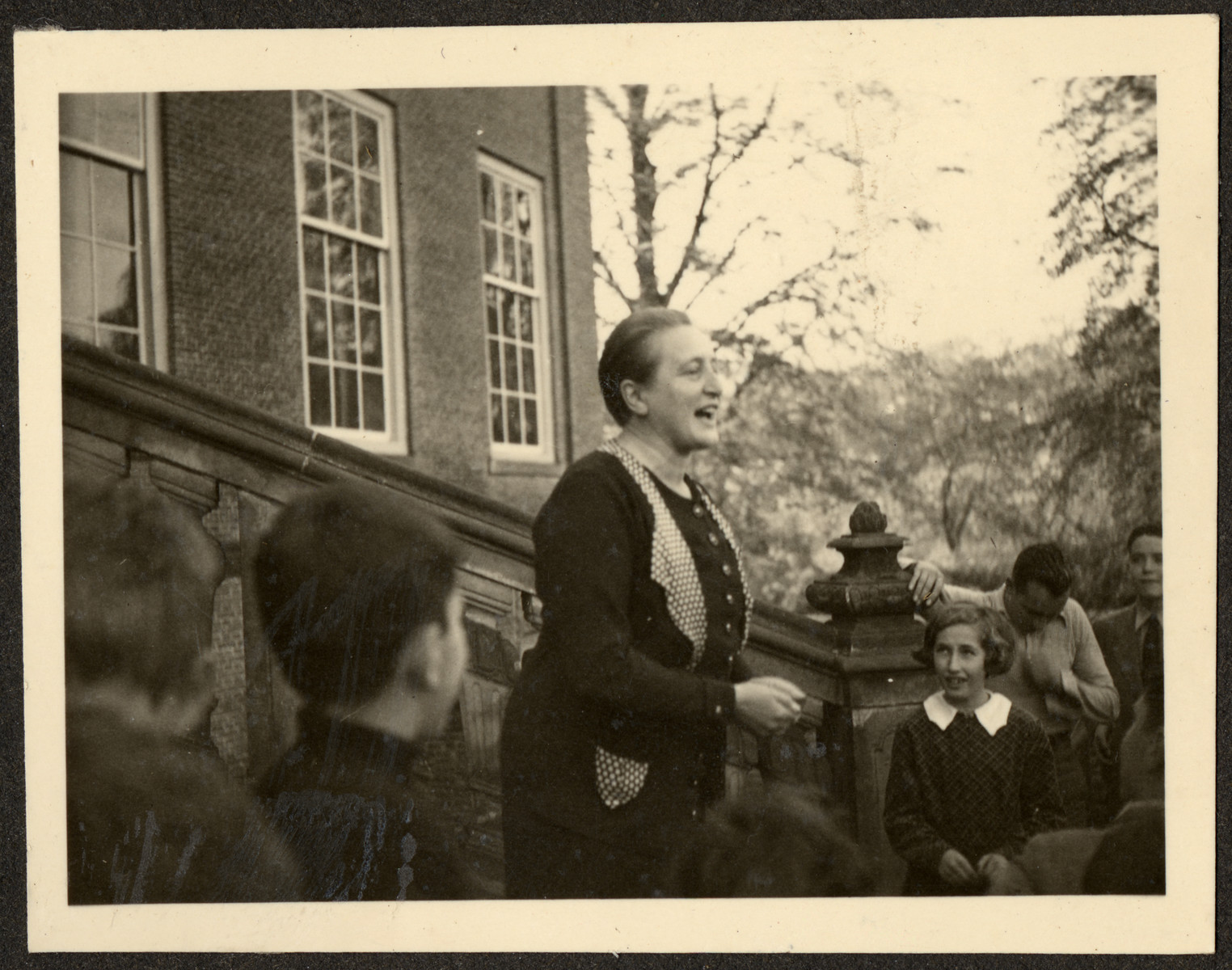 A teacher leads an activity for students, many of them German Jewish refugees, on the steps of a Quaker boarding school in Eerde.