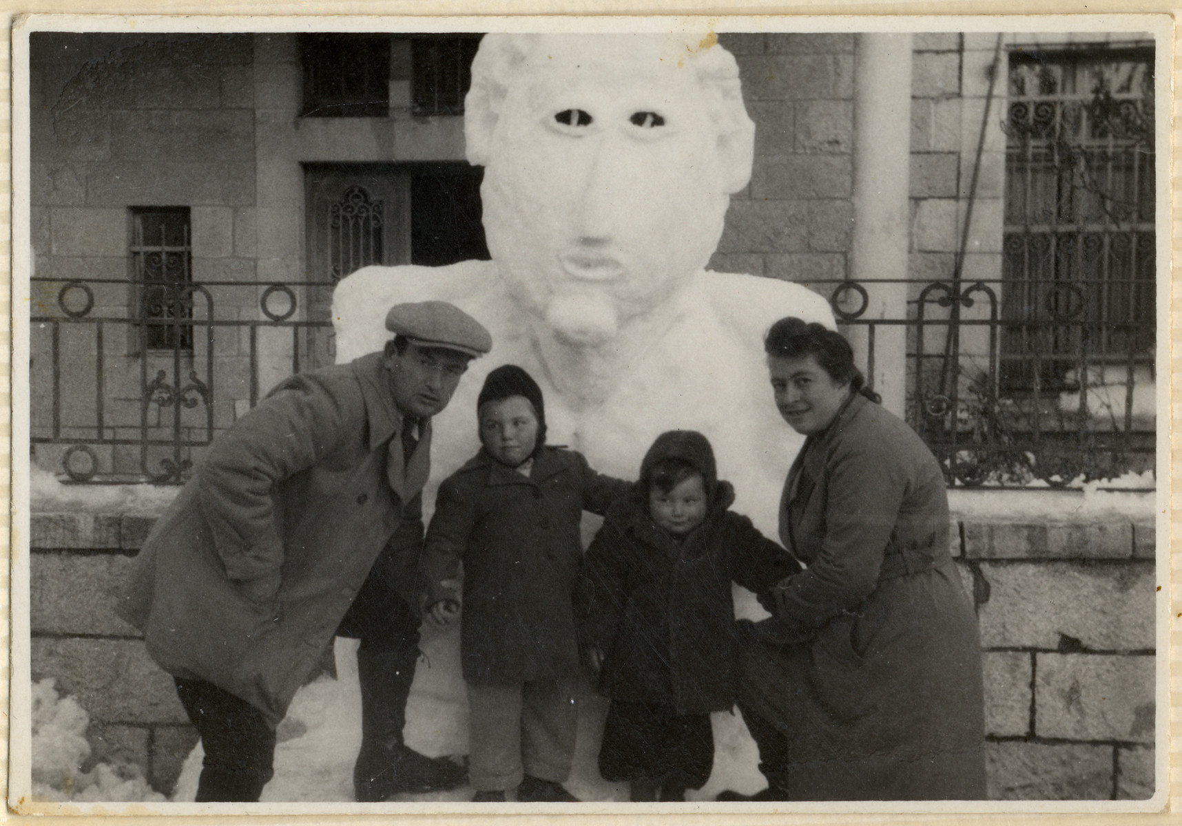 The Kohl family poses in front of a large snow sculpture in the Hofgeismar displaced persons camp.

From left to right are Emil, Miriam, Sam and Dora Kohl.