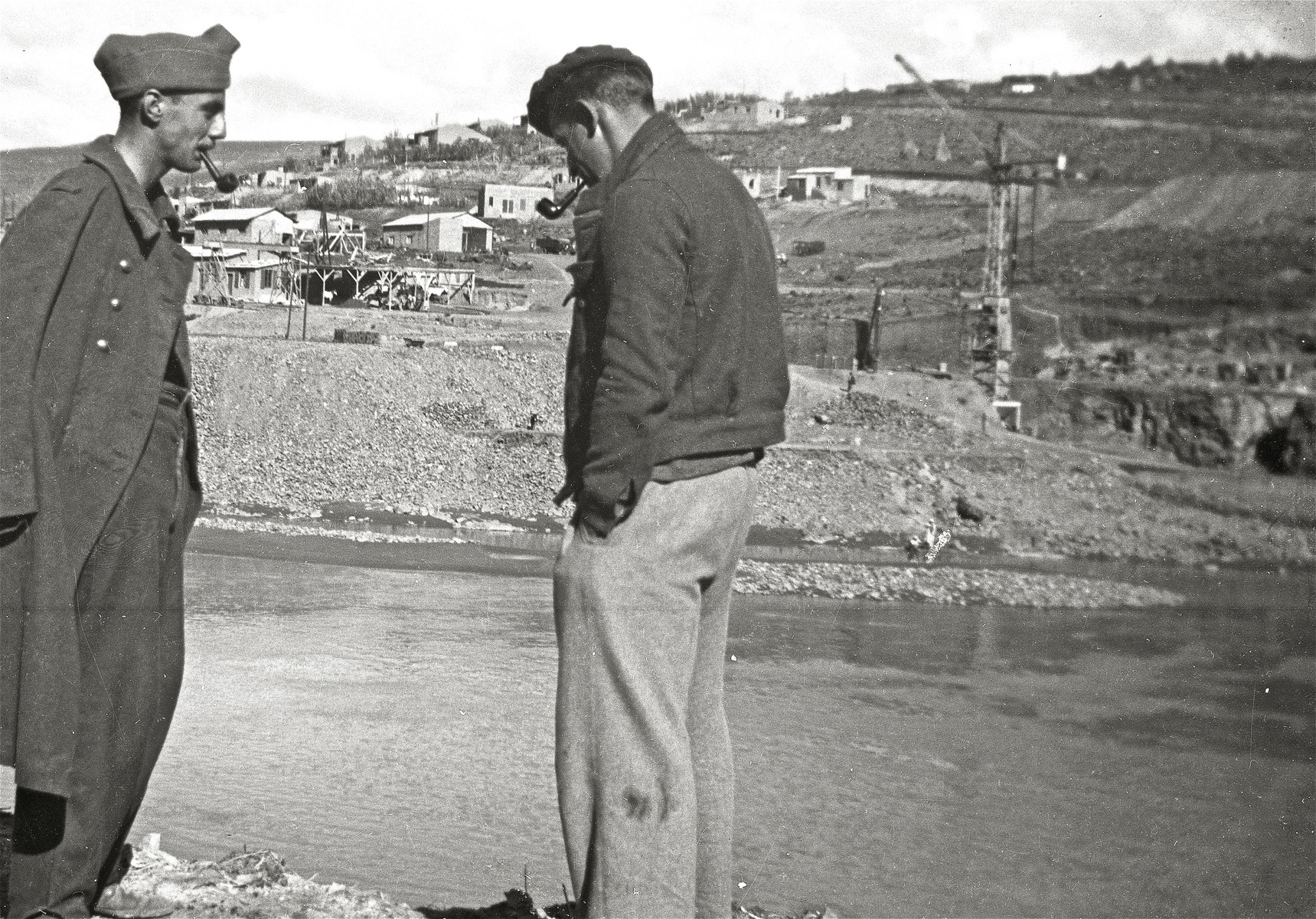 Two prisoners stand by the river and smoke pipes at the Im Fout labor camp in Morocco.

Pictured are Sami Dorra and Rosenthal.