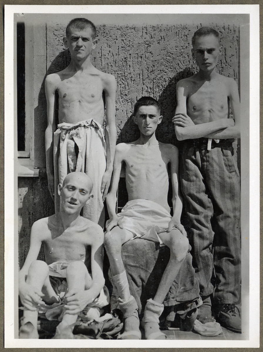 Close-up portrait of four survivors of the Buchenwald concentration camp.