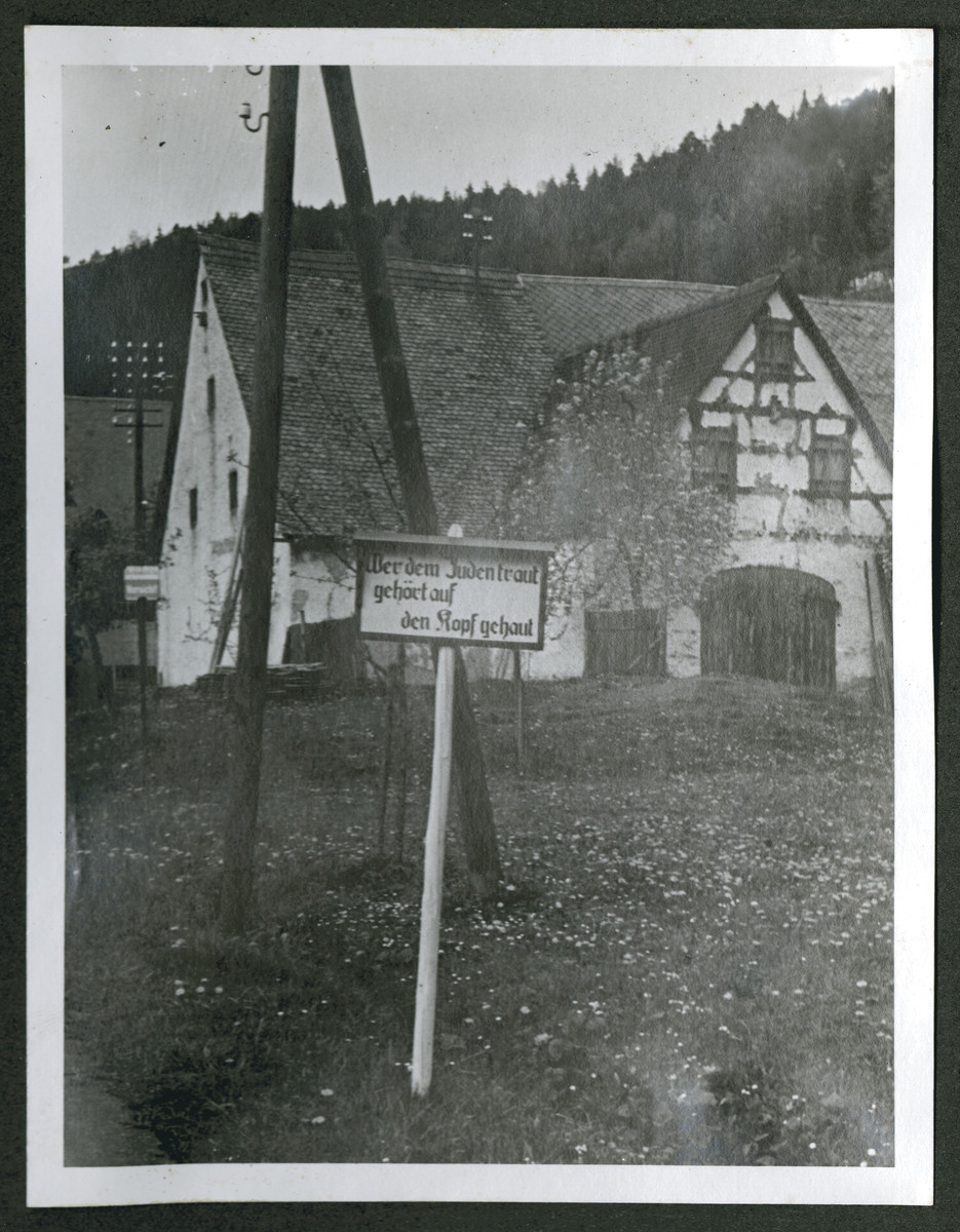 One photograph from an album of antisemitic signs in Germany.

The sign (in German) reads, "Wer dem Juden traut gehoert auf den Kopf gehaut."  [He who trusts the Jews needs a good knock on the head.]
