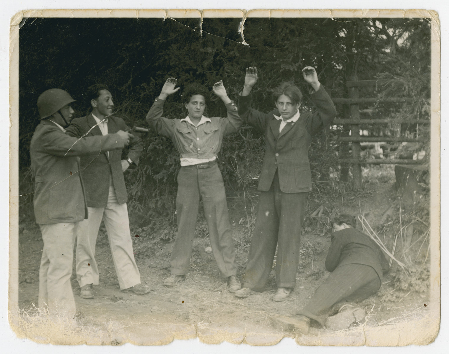 Young survivors play act an arrest.

One of the men is Mordechai Hellman.