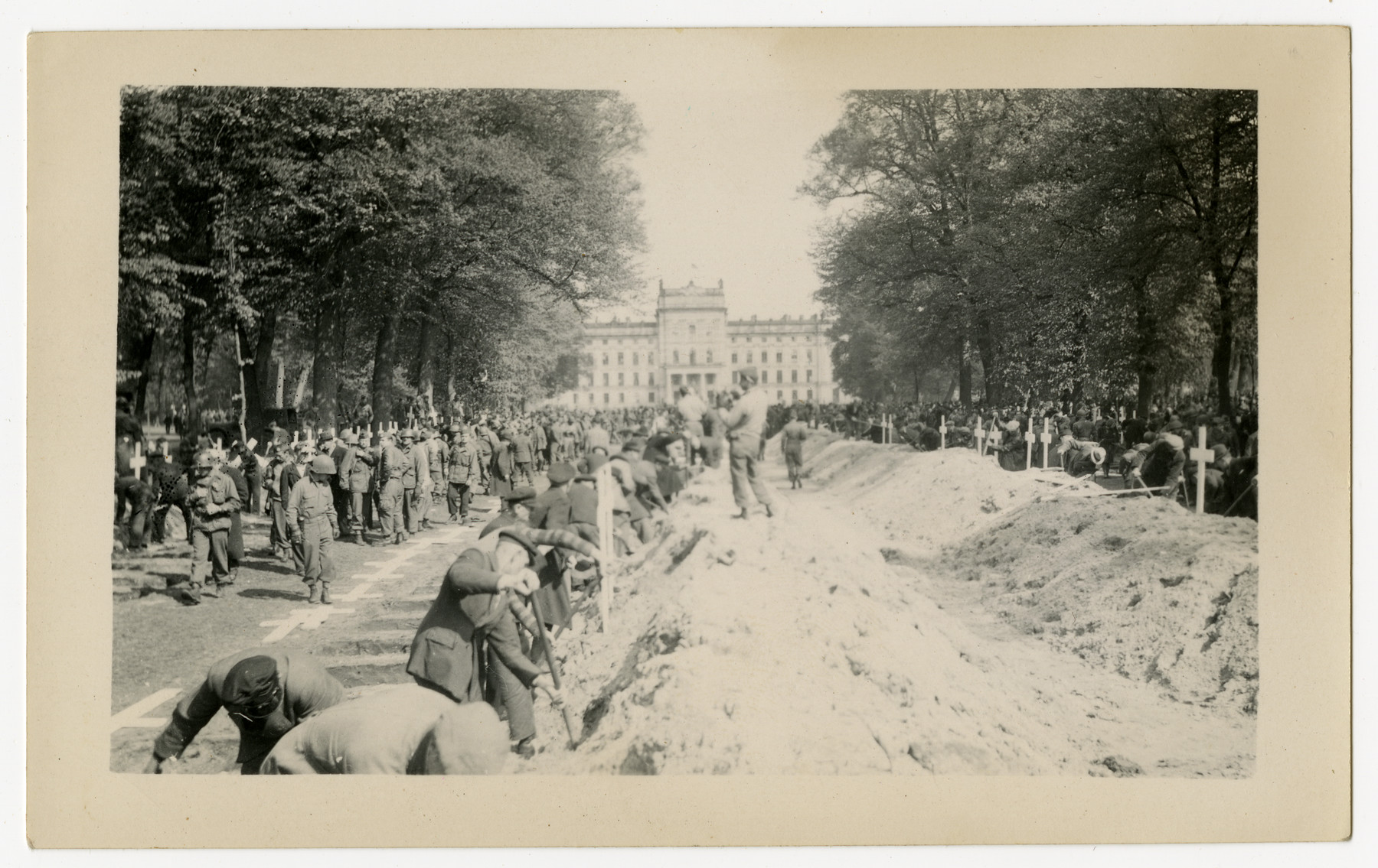 The population of Ludwigslust digs graves on the palace grounds of the Archduke of Mecklenburg, where they have been forced by U.S. troops to bury the bodies of prisoners killed in the Woebbelin concentration camp.