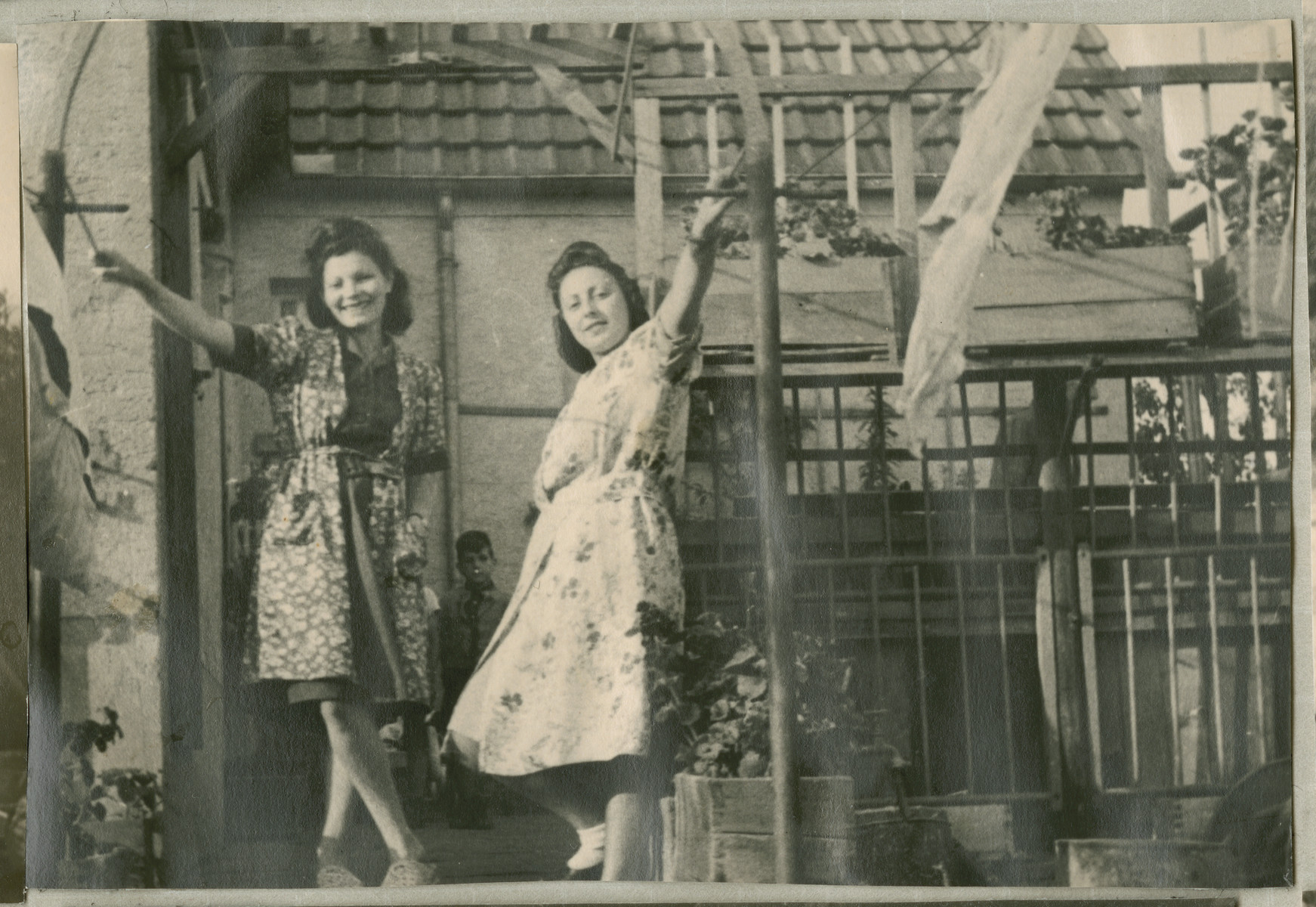 Hanna Bratman and her sister-in-law Hanka Bratman Fisch stand outside a house in the Lampertheim displaced person camp.