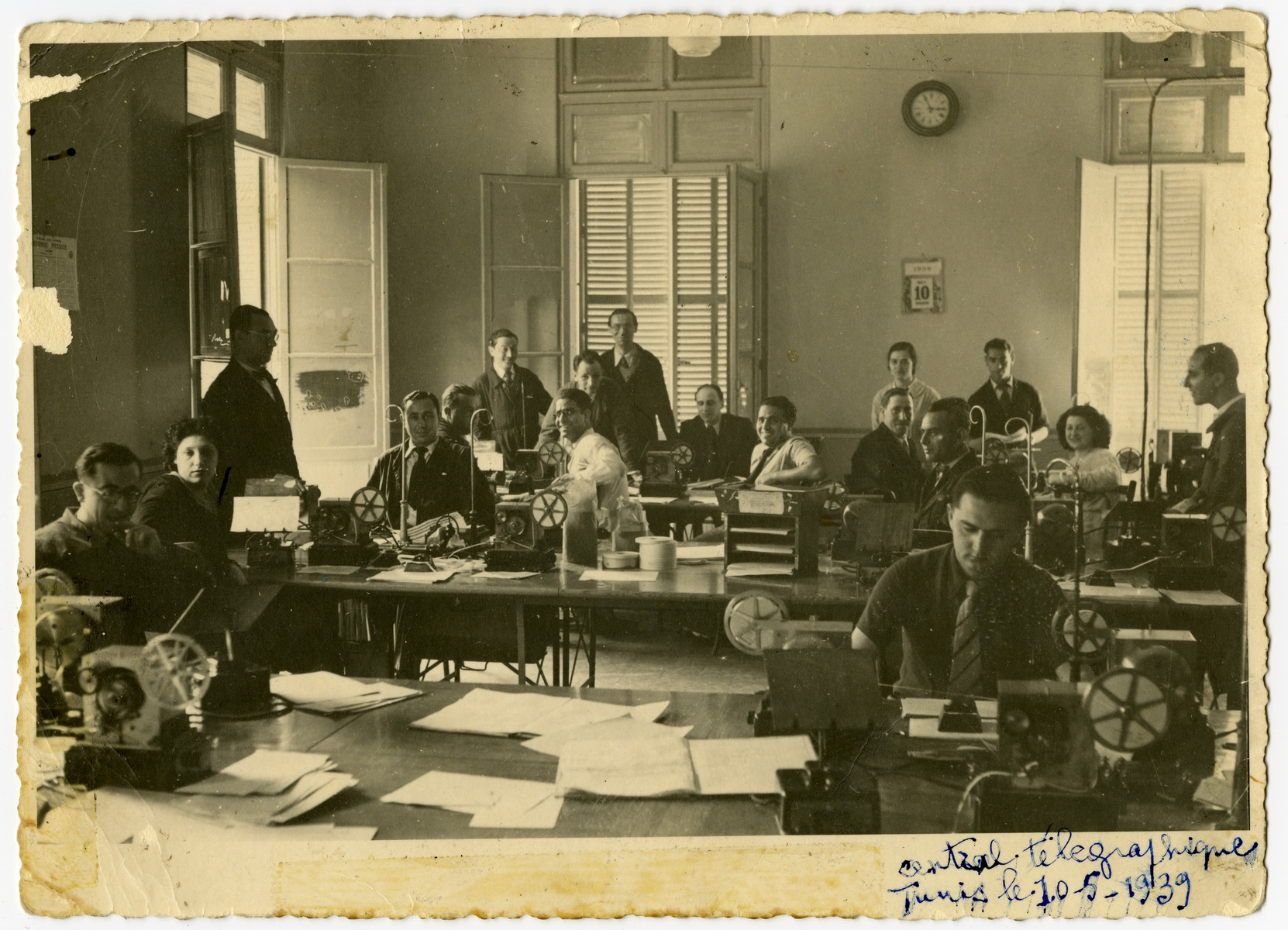 Workers of the Central Telegraph Office in Tunis operate their teletypes.

Arlette El Haik (later Benichou) is pictured near the window on the right.  Also pictured are Bost, Clance, Florane, Mlle Allouche, Capot, Taieb, Costa, Vitalis, Ousedere and Canavaggio.