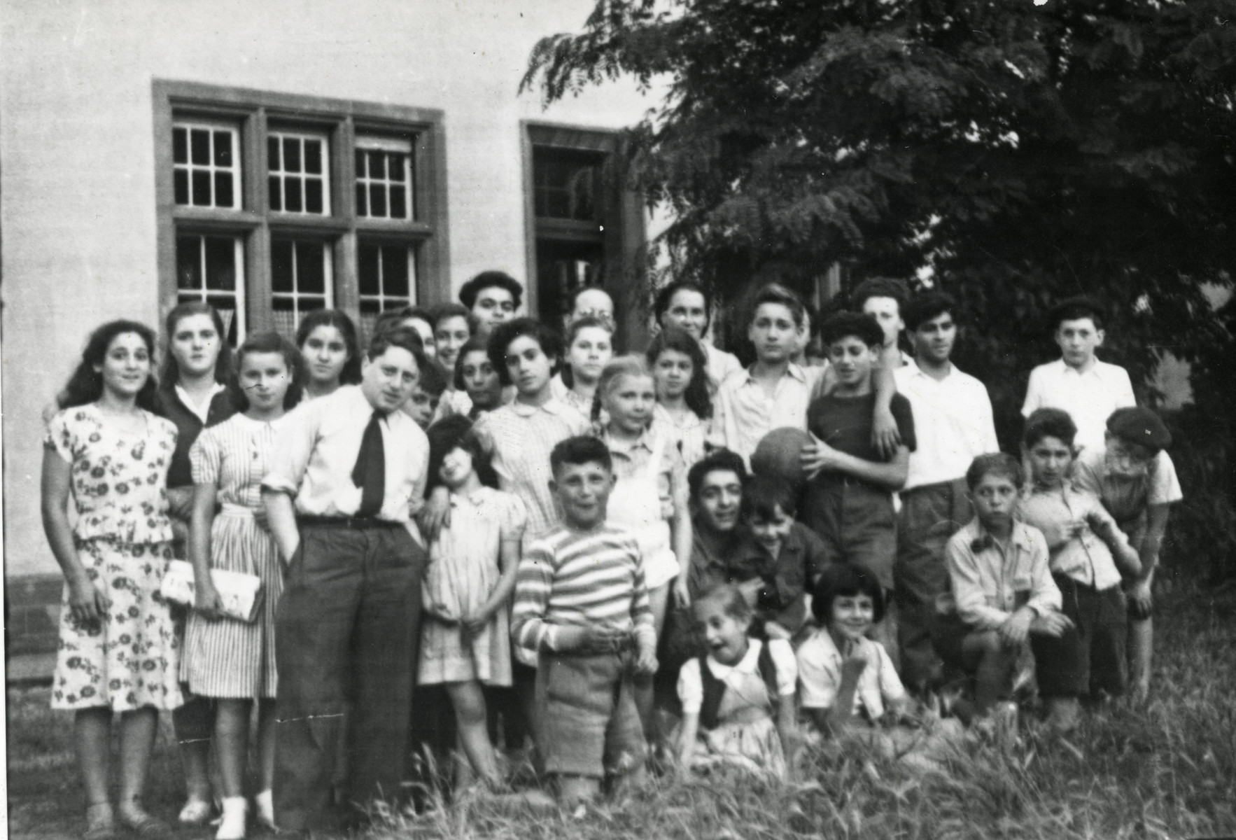 Group portrait of "Les Cigognes" (the storks), children in the Haguenau children's home.

Pictured in back are the directors, Vivette and Julien Samuel.
