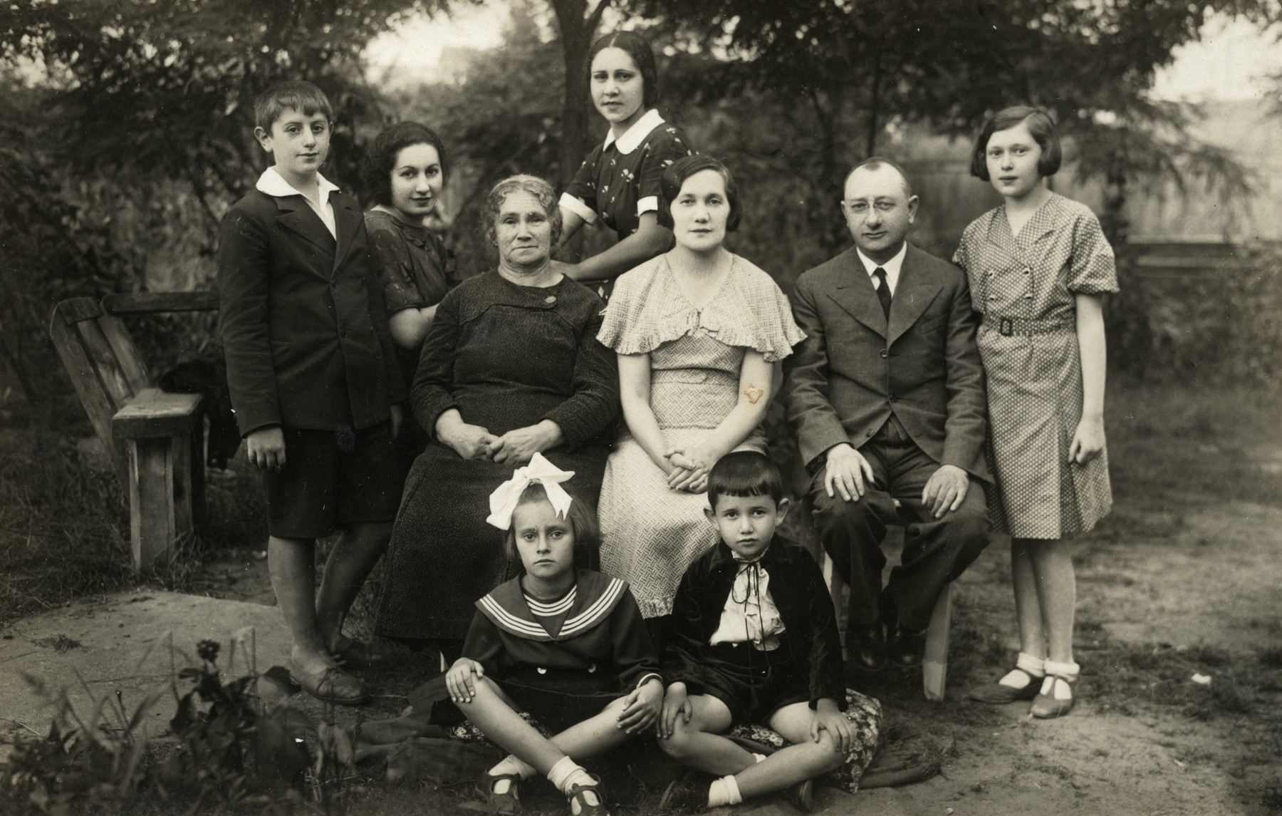 Group portrait of the extended Kracowski family at their summer dacha.

Ewa Kracowska's parents, Esther and Dr. Samuel Kracowski,  are seated in the middle; Ewa is standing on the far right; and her brother Julek is seated in front, on the right.  Berl Rabinovitch is standing on the far left.
