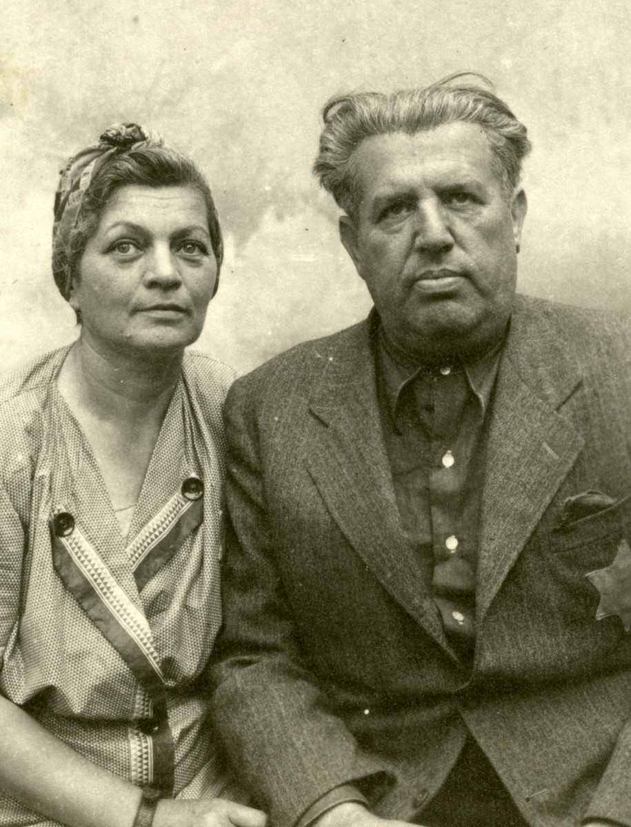 Gyula and Flora Breuer (Eli's aunt and uncle) sit for a studio portrait in Kolombus, Hungary.  They are wearing Star of David badges.