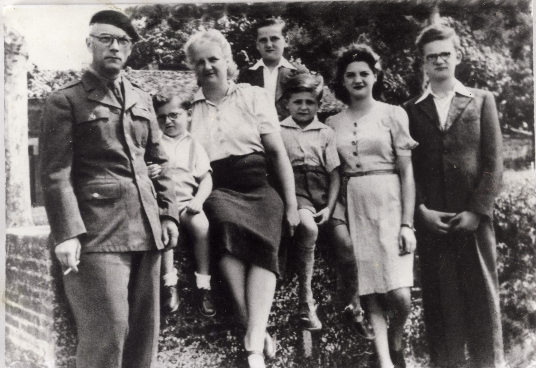 Five children reunite with parents after the war.  Father is wearing a resistance Macquis uniform.